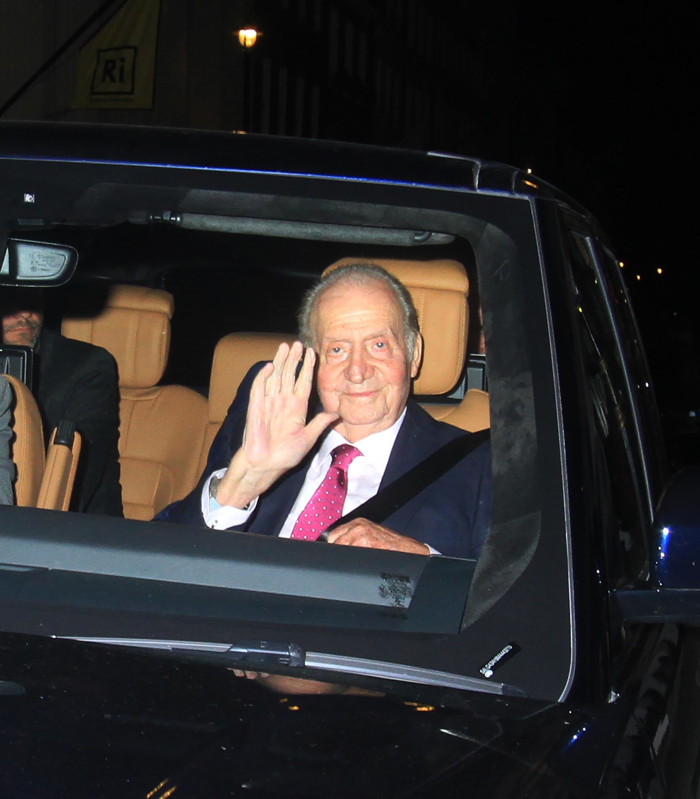 Juan Carlos I saluda en el interior de un coche en Londres.