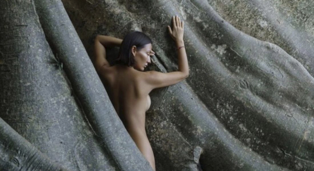 Luiza Kosykh posando desnuda junto a un árbol sagrado de Indonesia.