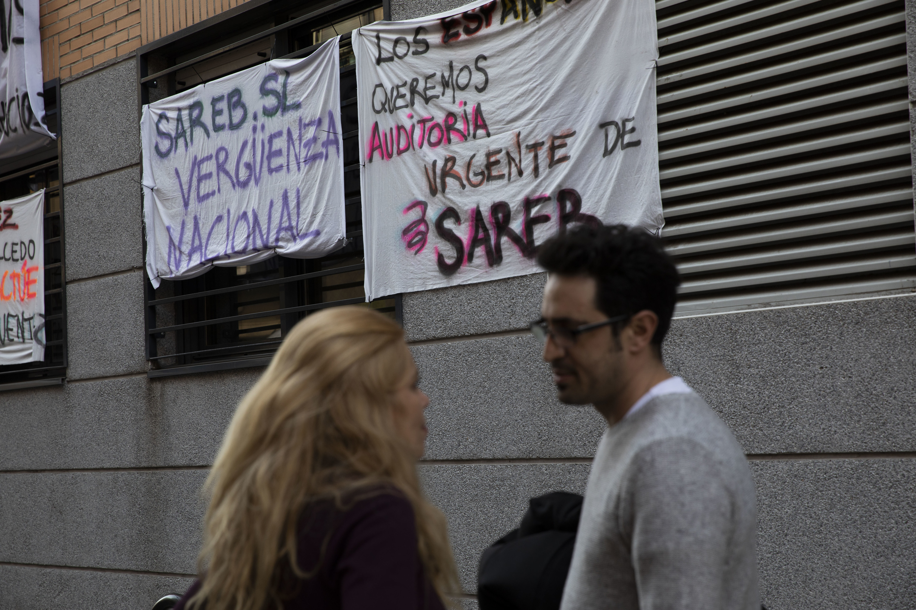 Una pareja ante un edificio amenazado de desahucio, en el madrileño barrio de Carabanchel.