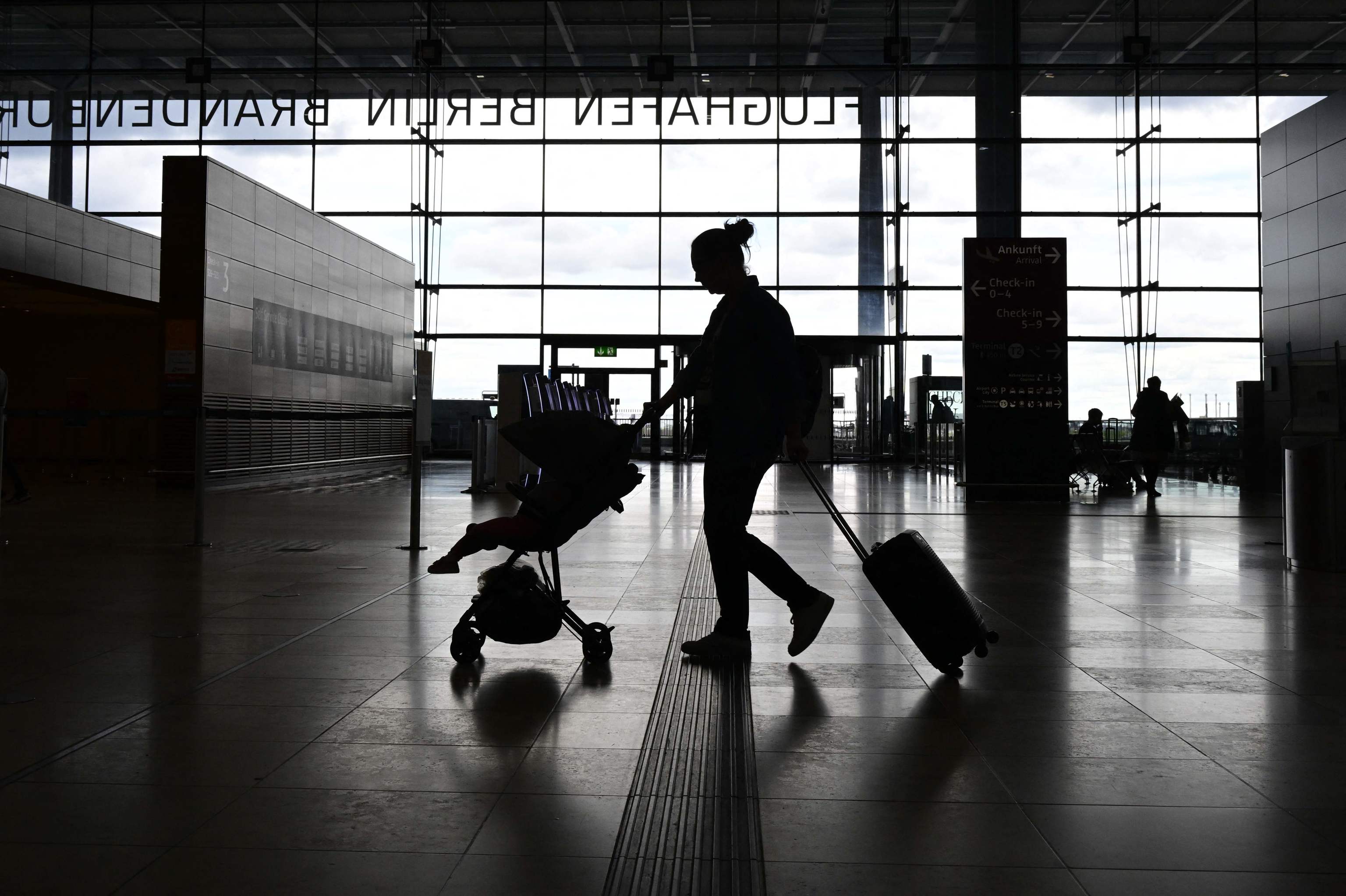 Una mujer empuja un carrito de bebé en un aeropuerto de Berlín.
