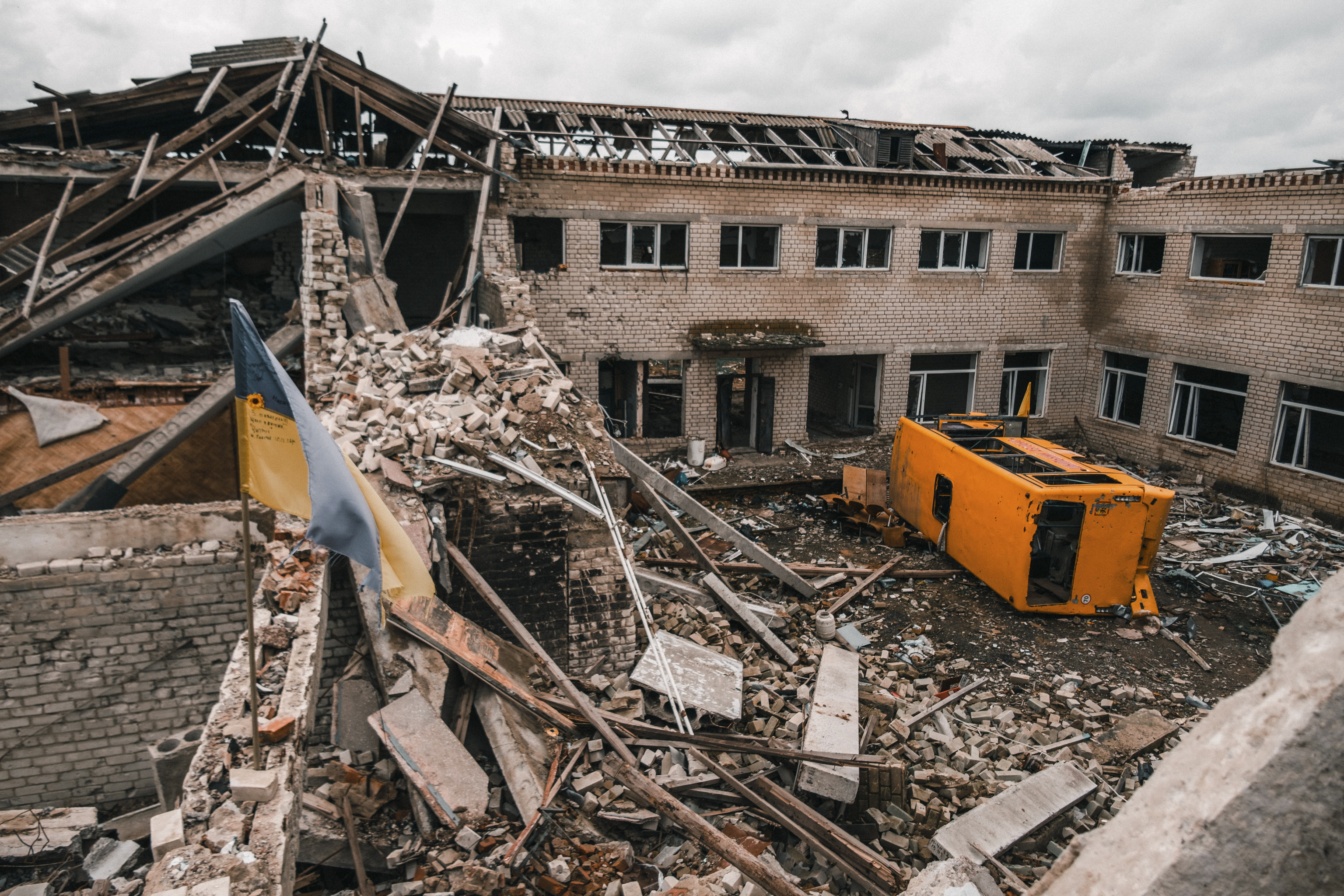 La escuela de Davydiv Brid, destruida, con un autobs escolar volteado.