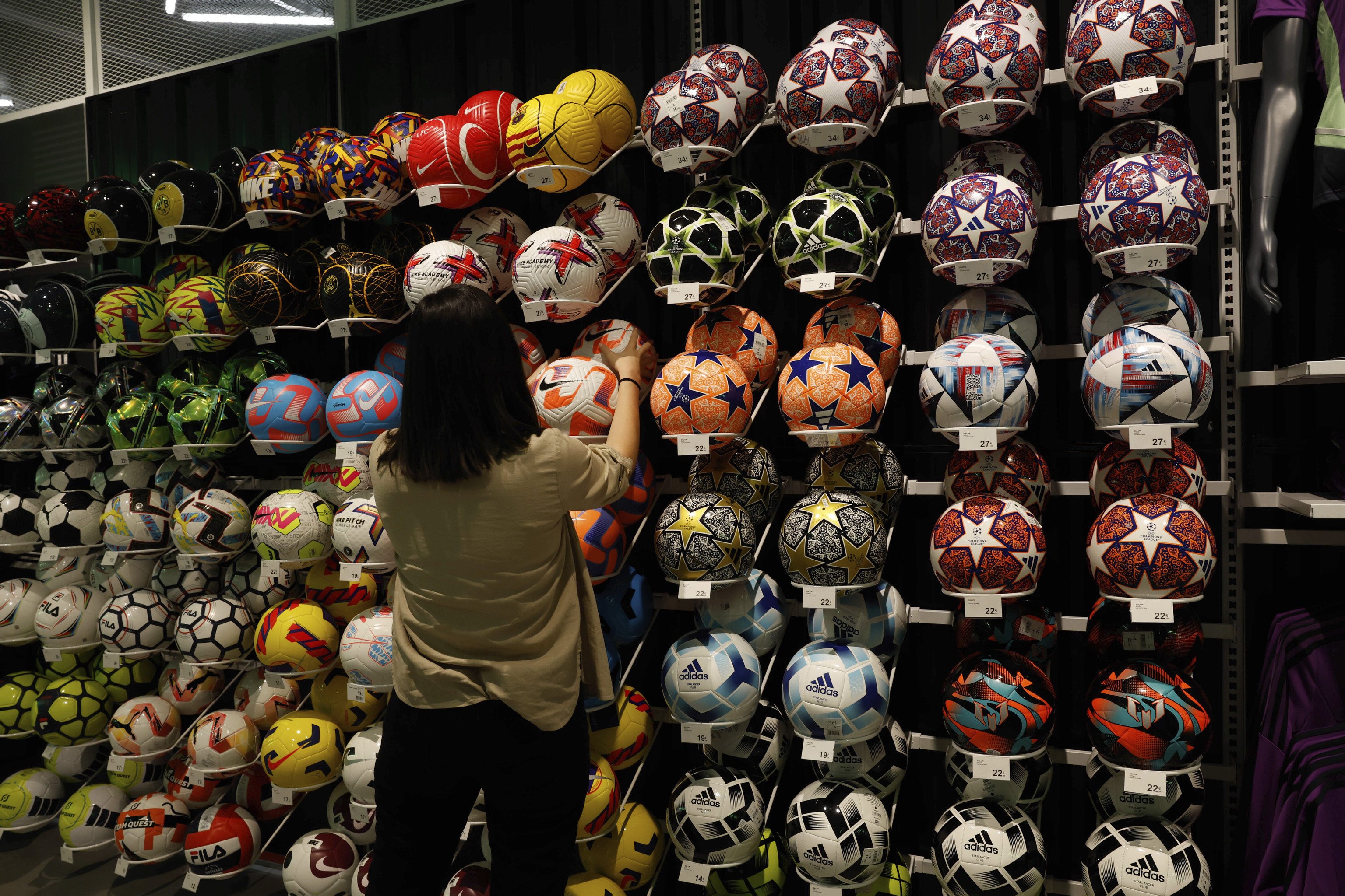 Una clienta, entre la gran variedad de balones en la seccin de ftbol, que incluye personalizacin de camisetas.