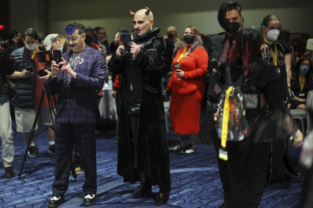 Participantes toman fotos durante el congreso satanista en Boston.