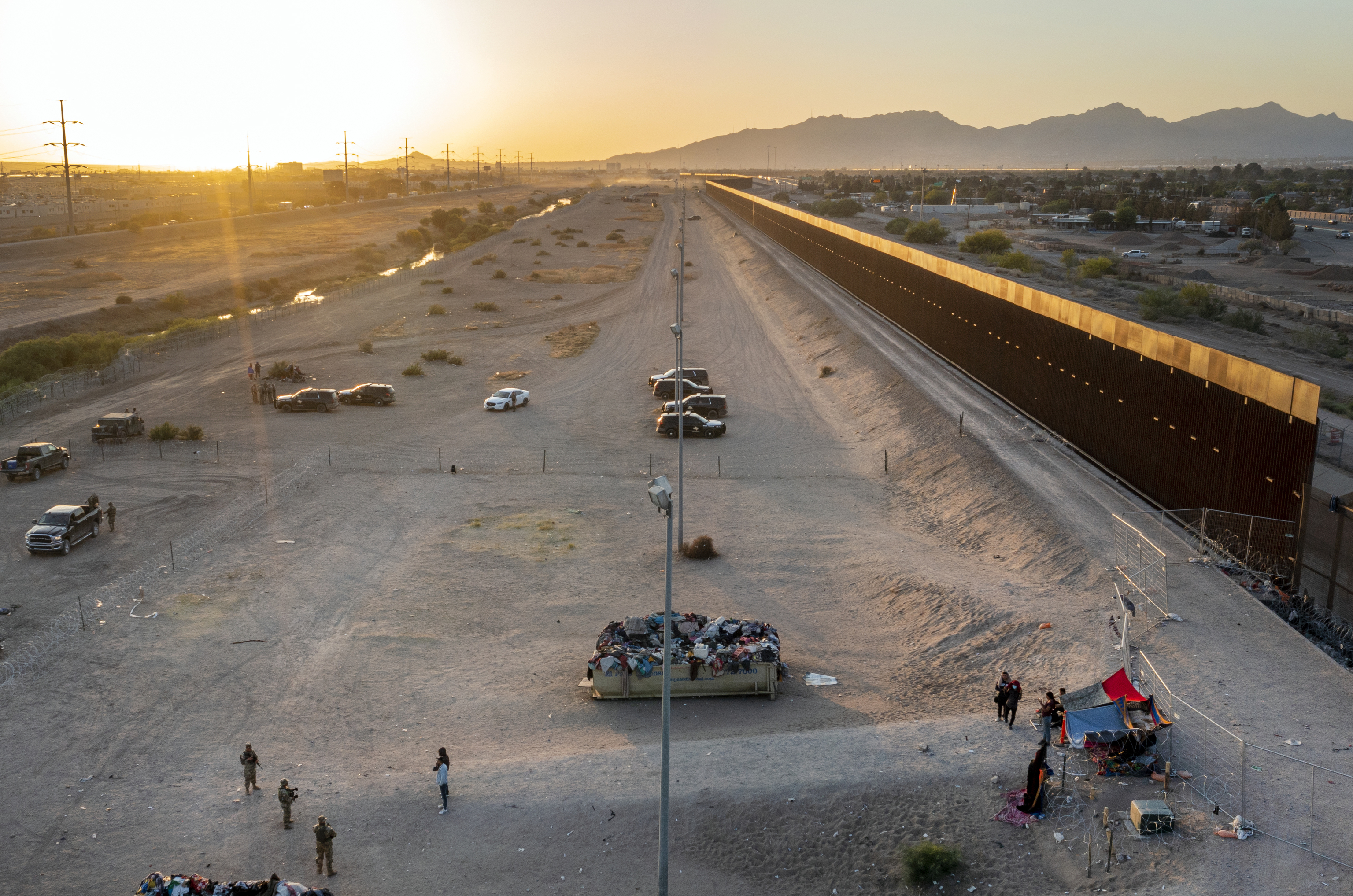 Un grupo de migrantes junto a la valla de El Paso.