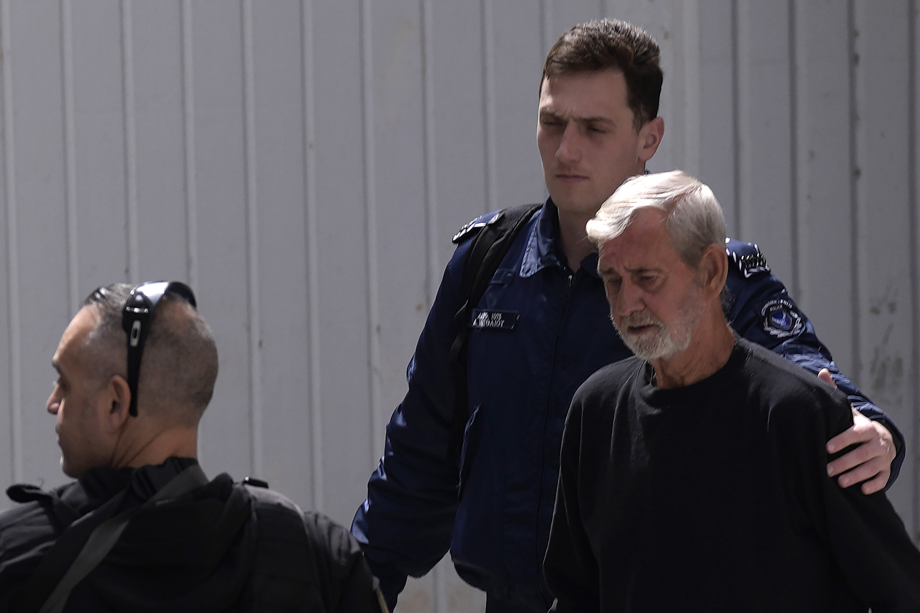 Agentes policiales escoltan a David Hunter, a su salida del juicio, en Pafos.
