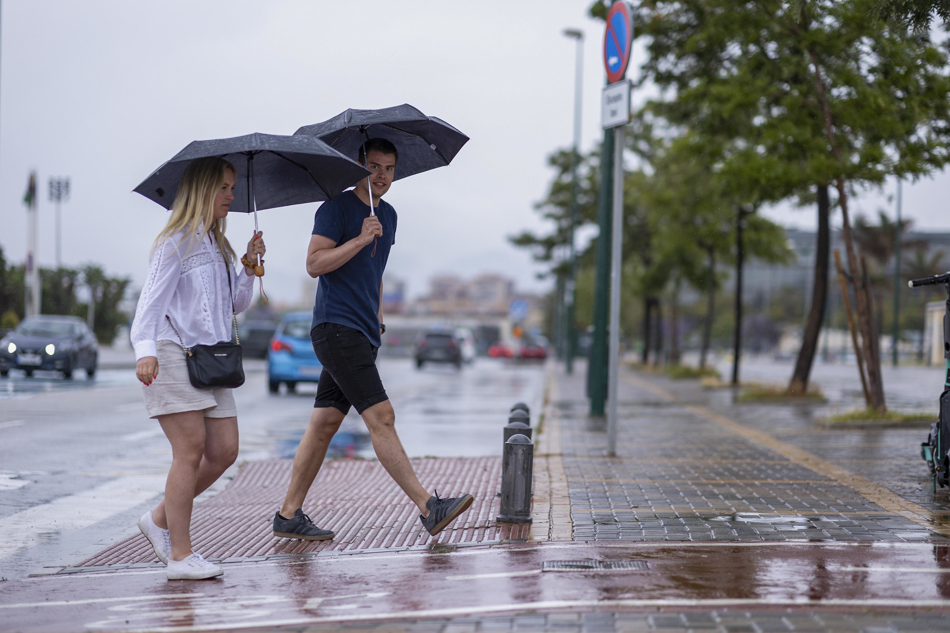 Una pareja con paraguas para protegerse de la lluvia en Málaga.