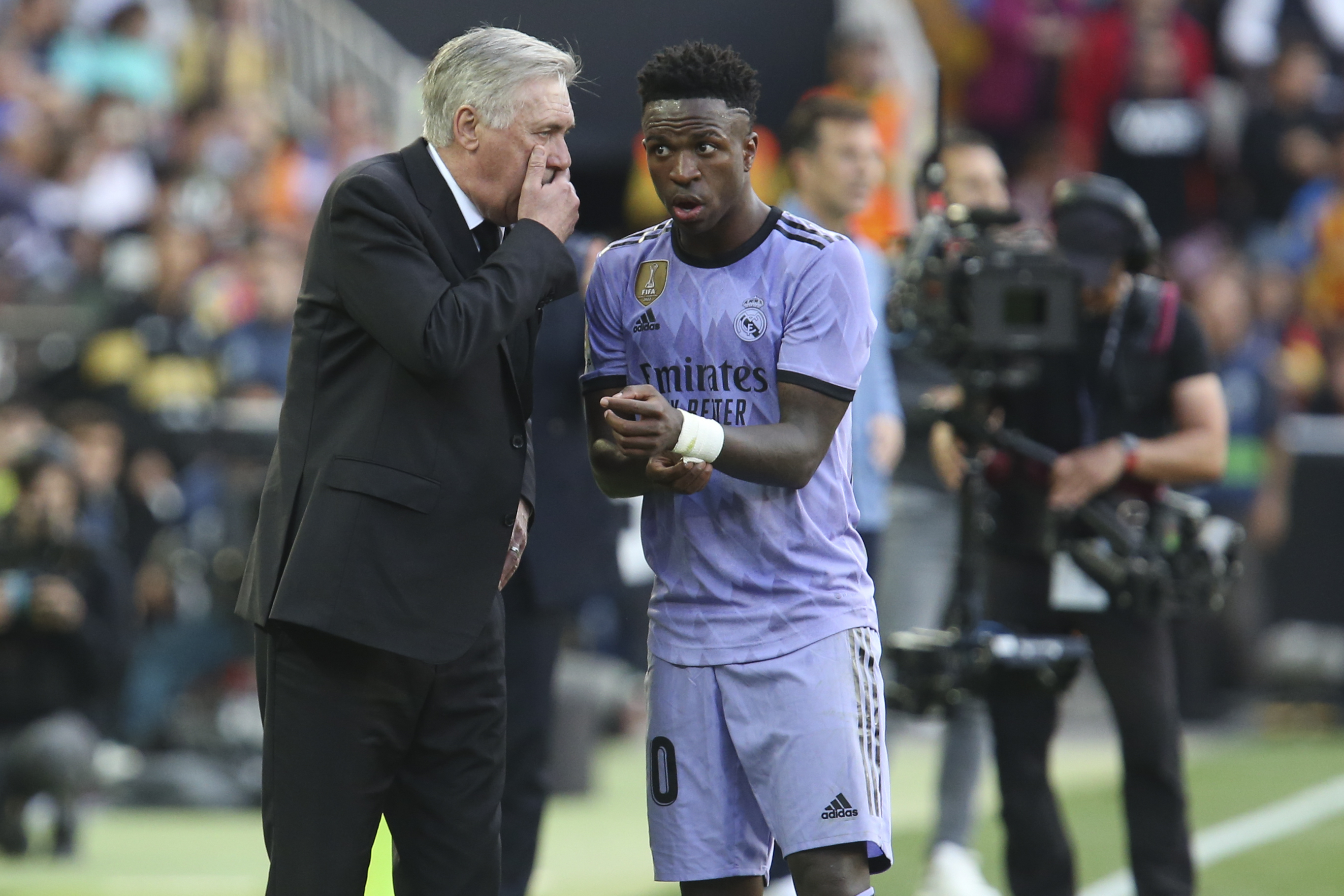 Ancelotti talks with Vinicius during the match.