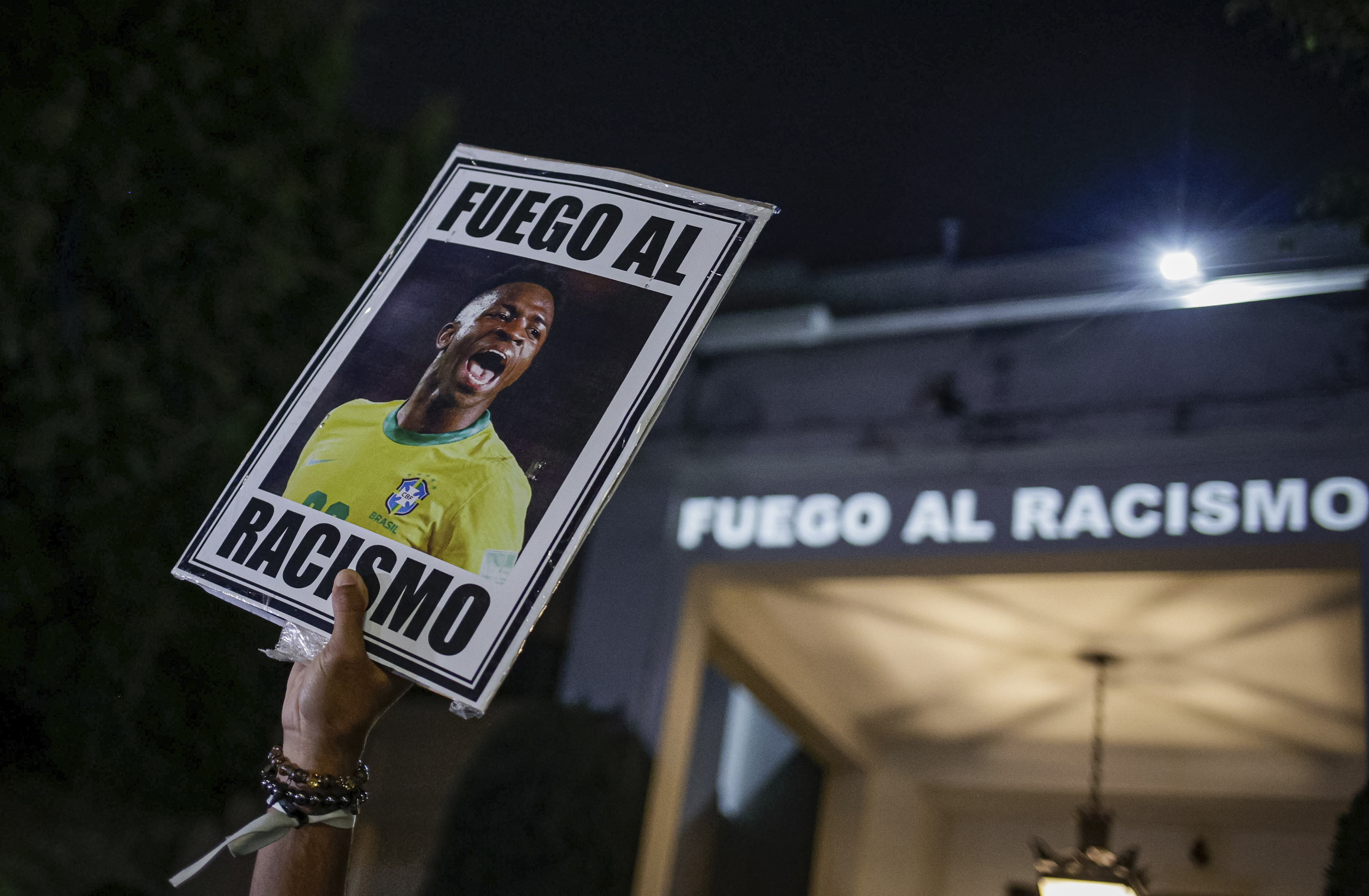 A protester holds a photo of Vinicius in front of the Spanish Consulate
