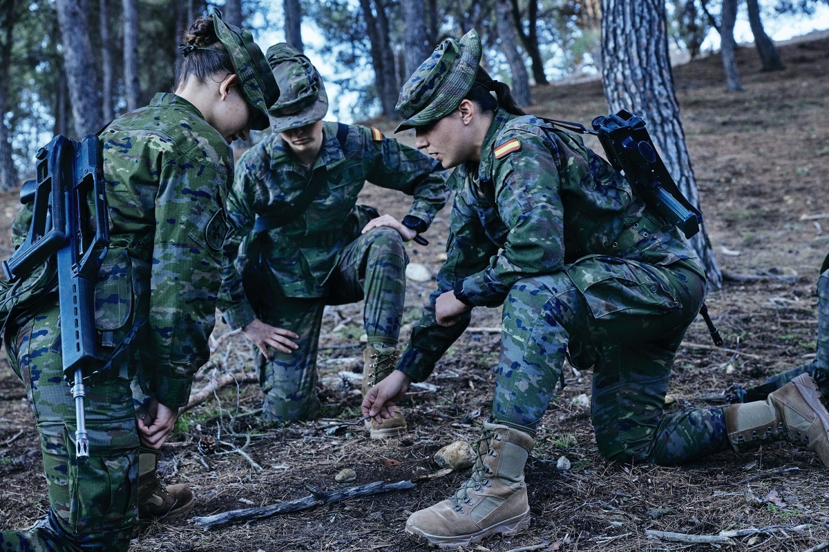 Damas cadete en el campo durante una instrucción, con el fusil KH al hombro.
