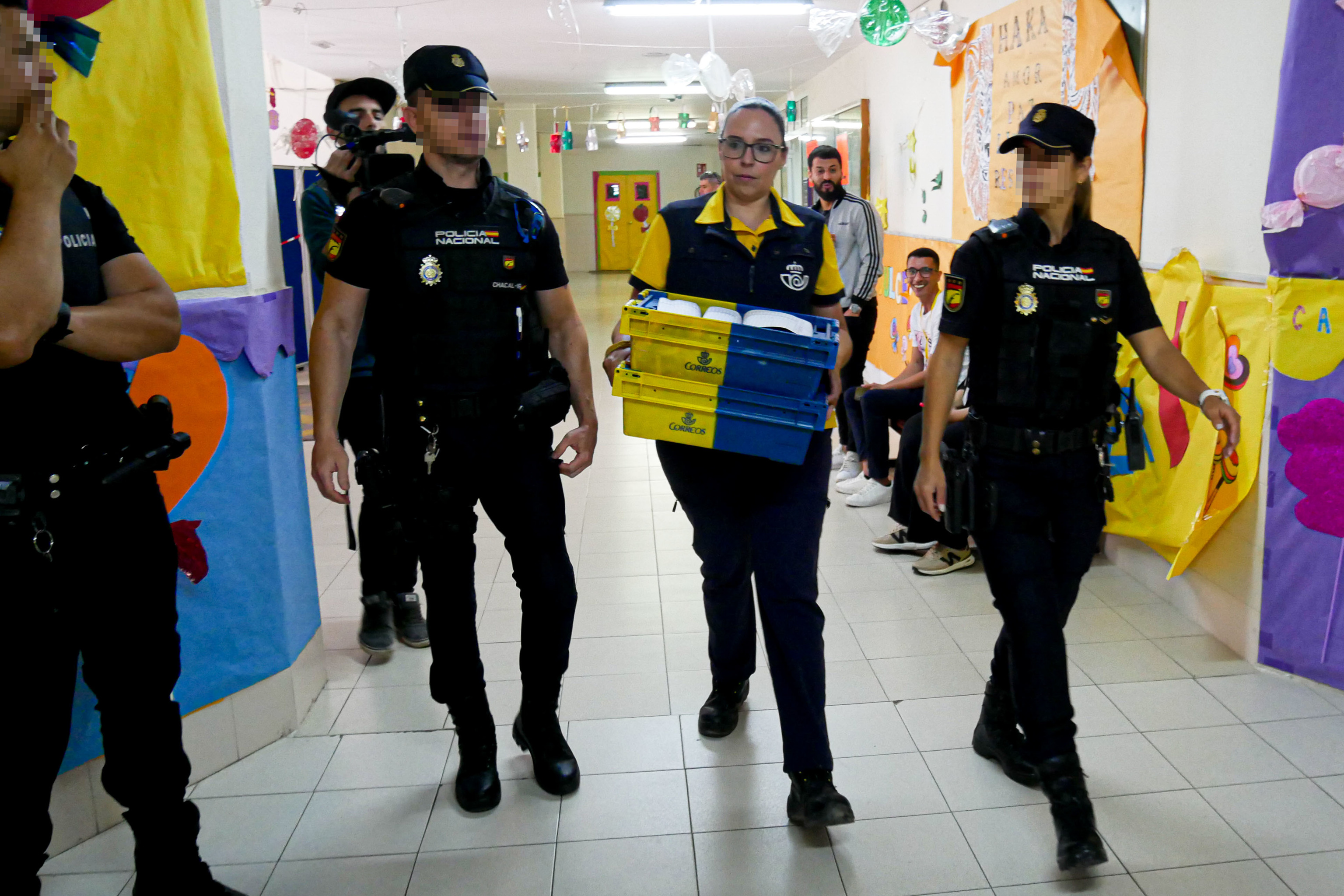 Agentes de Polica escoltan a una empleada de Correos que lleva votos a un colegio electoral de Melilla el 28-M.