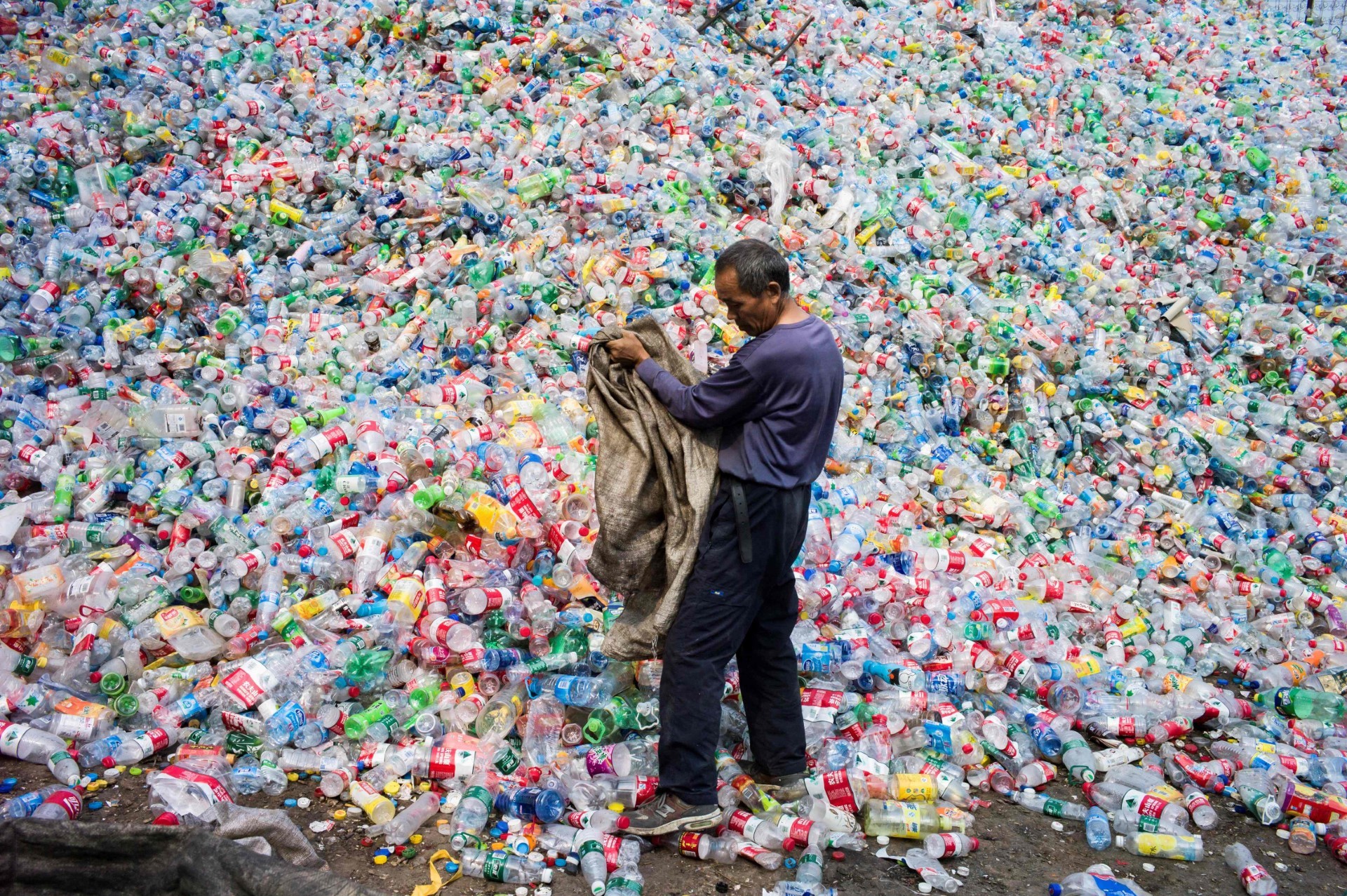 Un hombre rodeado de botellas de plstico en Dong Xiao Kou, a las afueras de Beijing