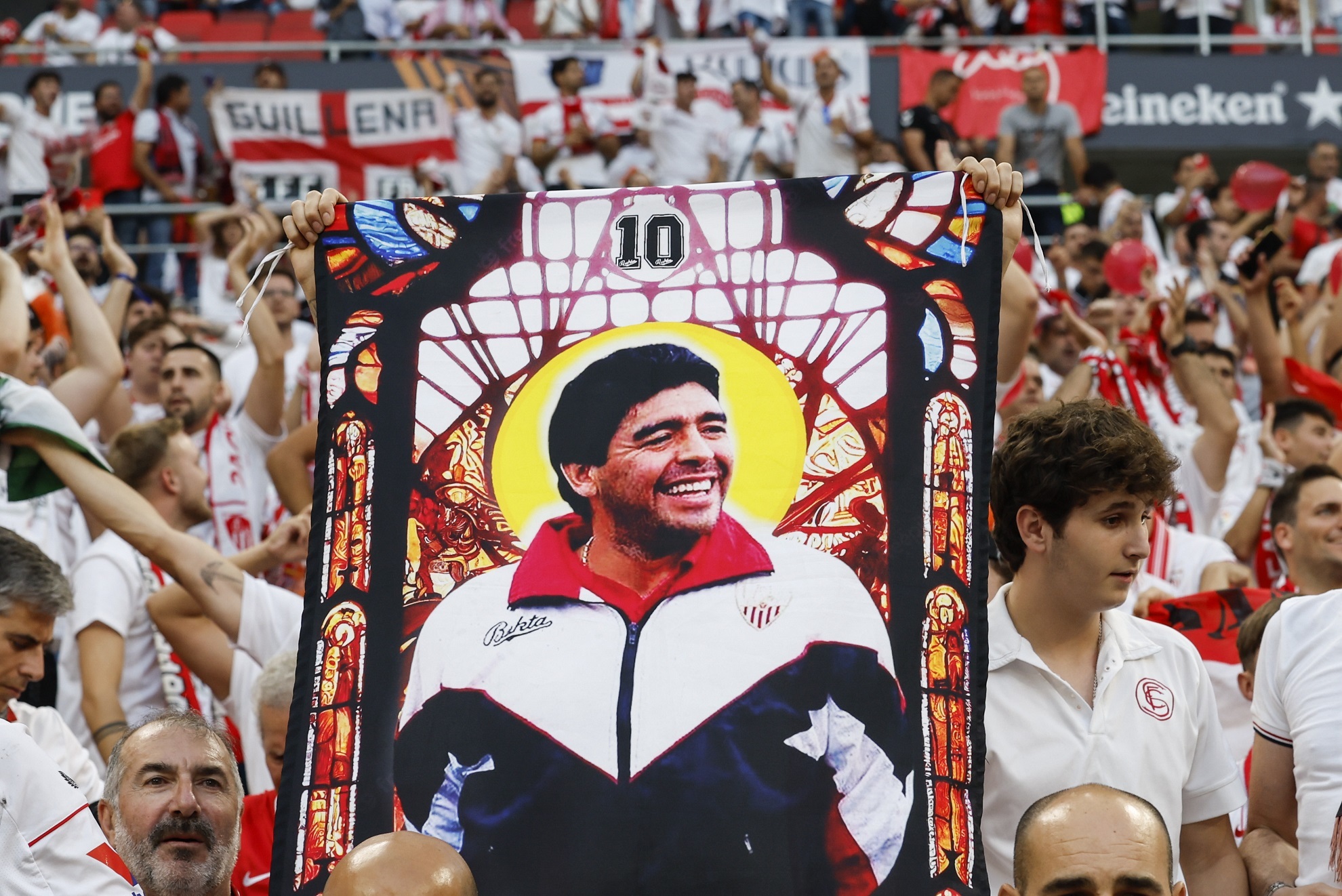Un aficionado del Sevilla sujeta una bandera de Maradona.