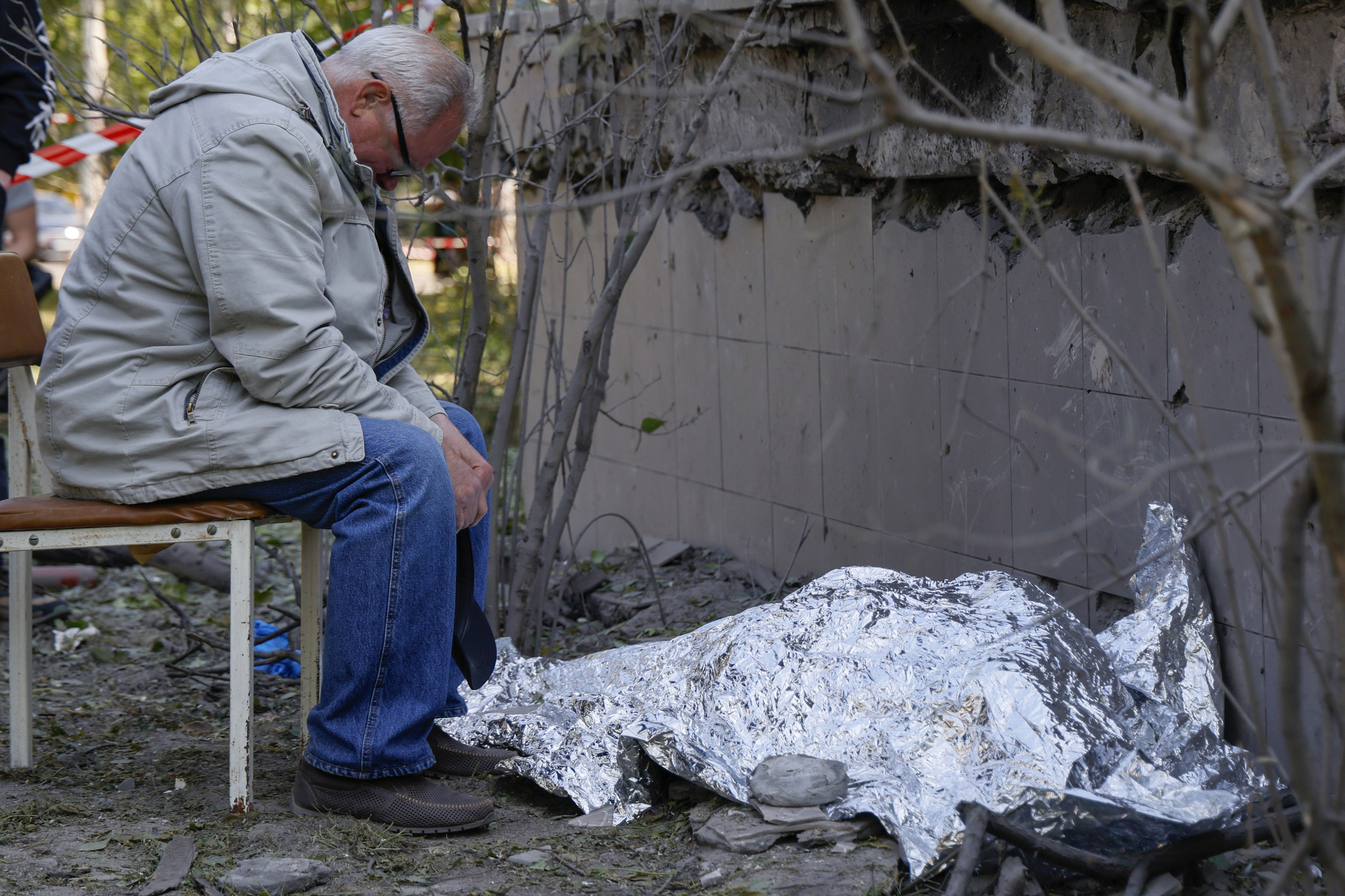 Un familiar llora cerca de un cadáver tras un ataque ruso en Kiev.