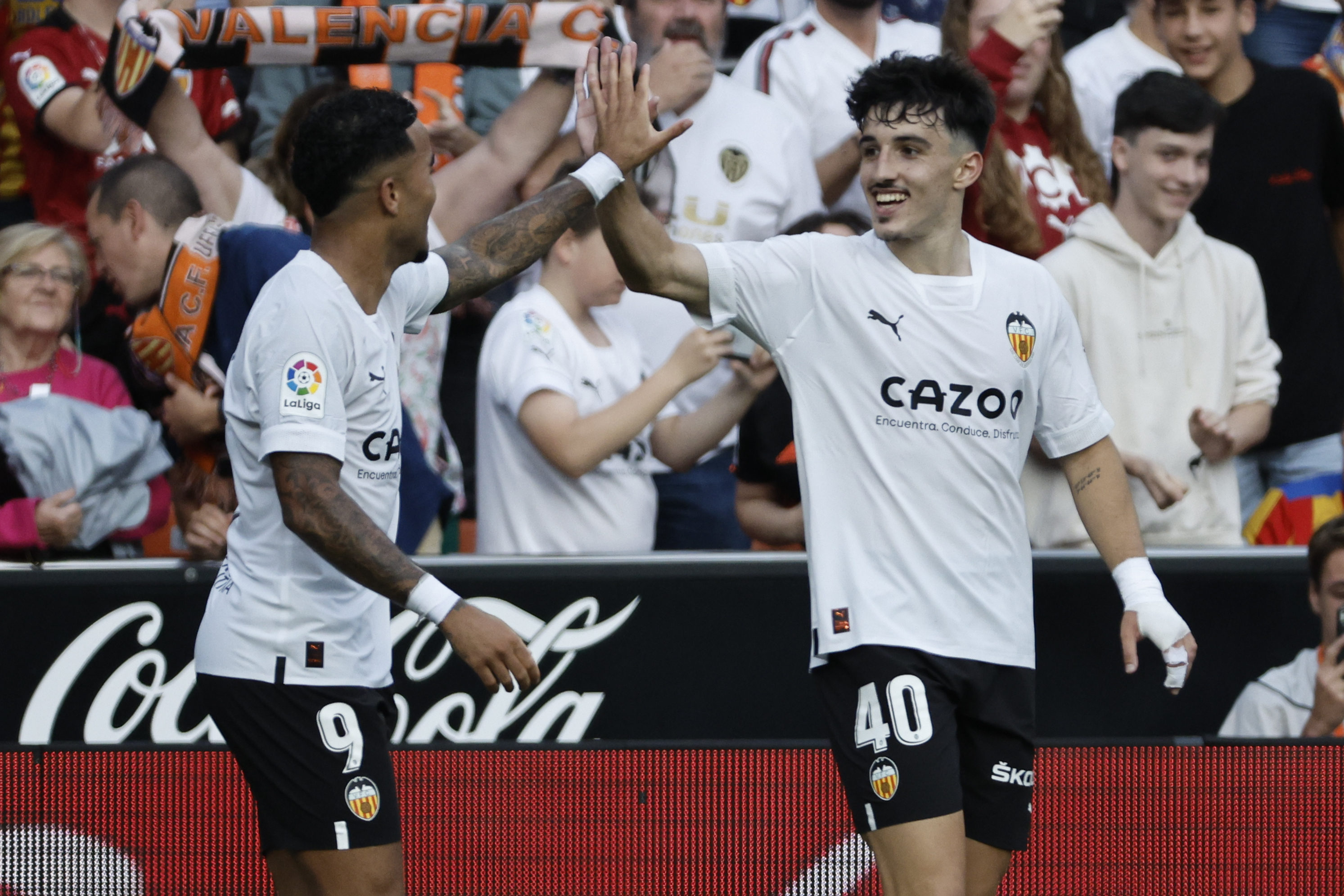 El delantero del Valencia Diego López celebra un gol con Justin Kluivert.