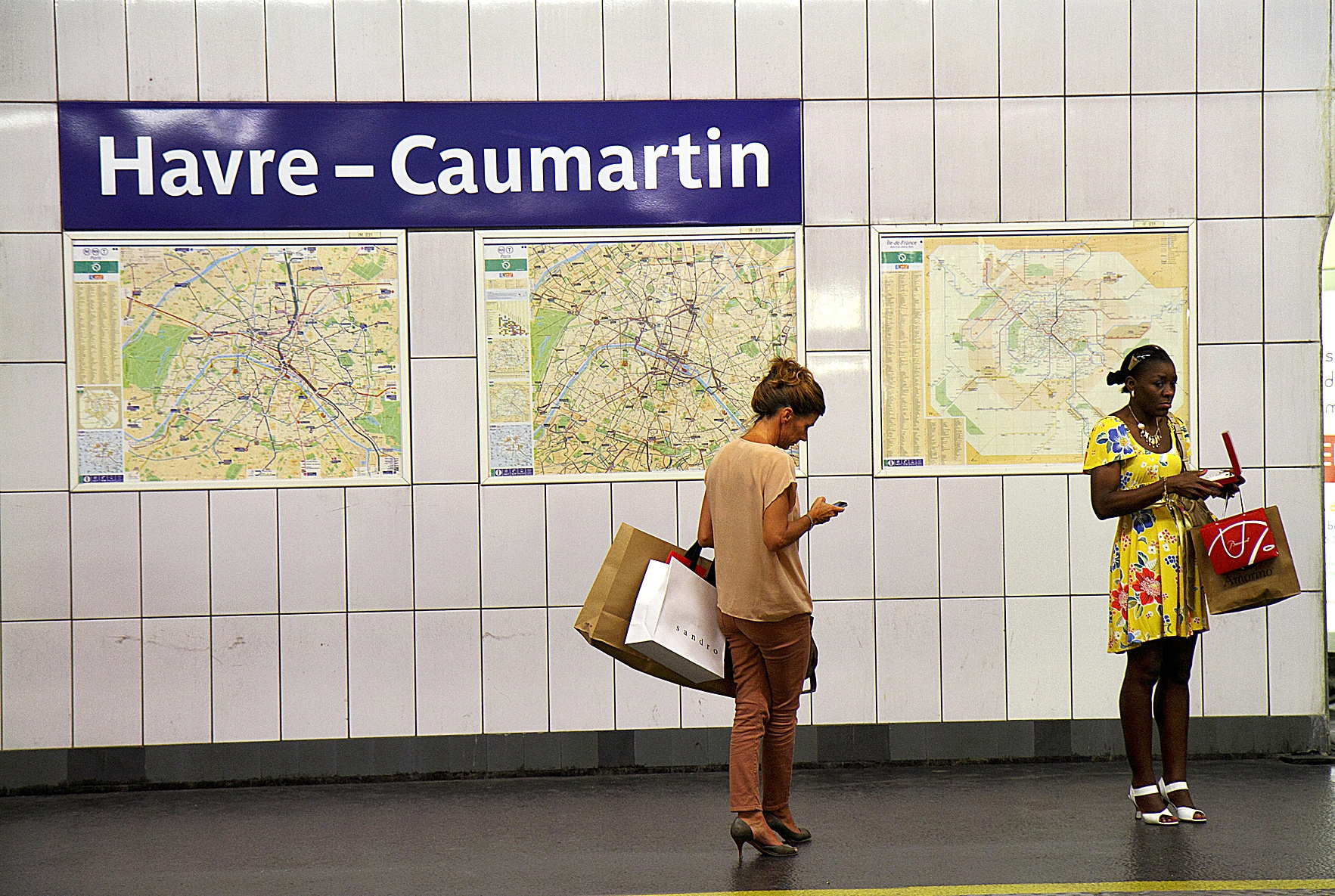Dos mujeres esperan el tren en una estación de metro de París.