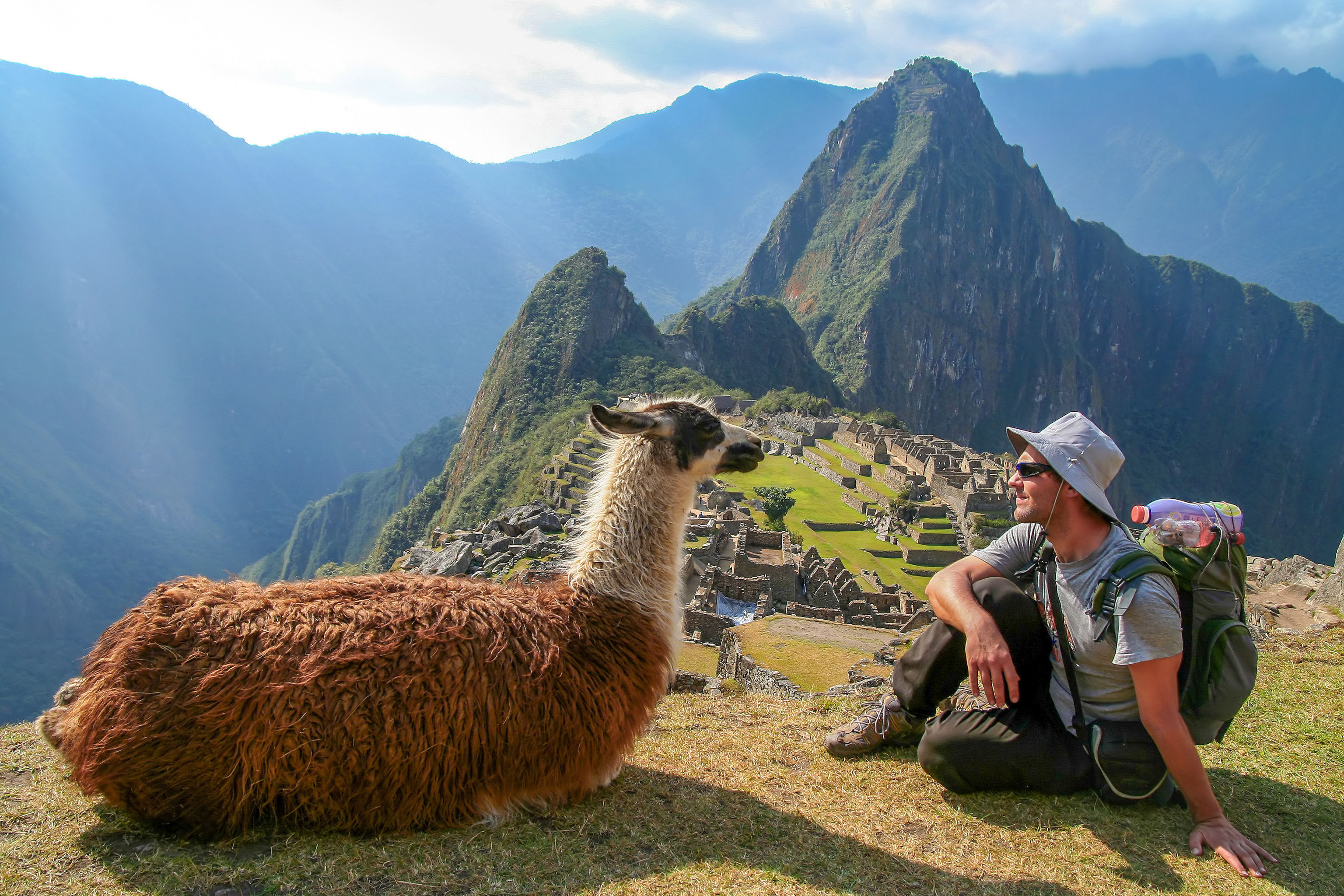 Un viajero con una llama en Machu Picchu.