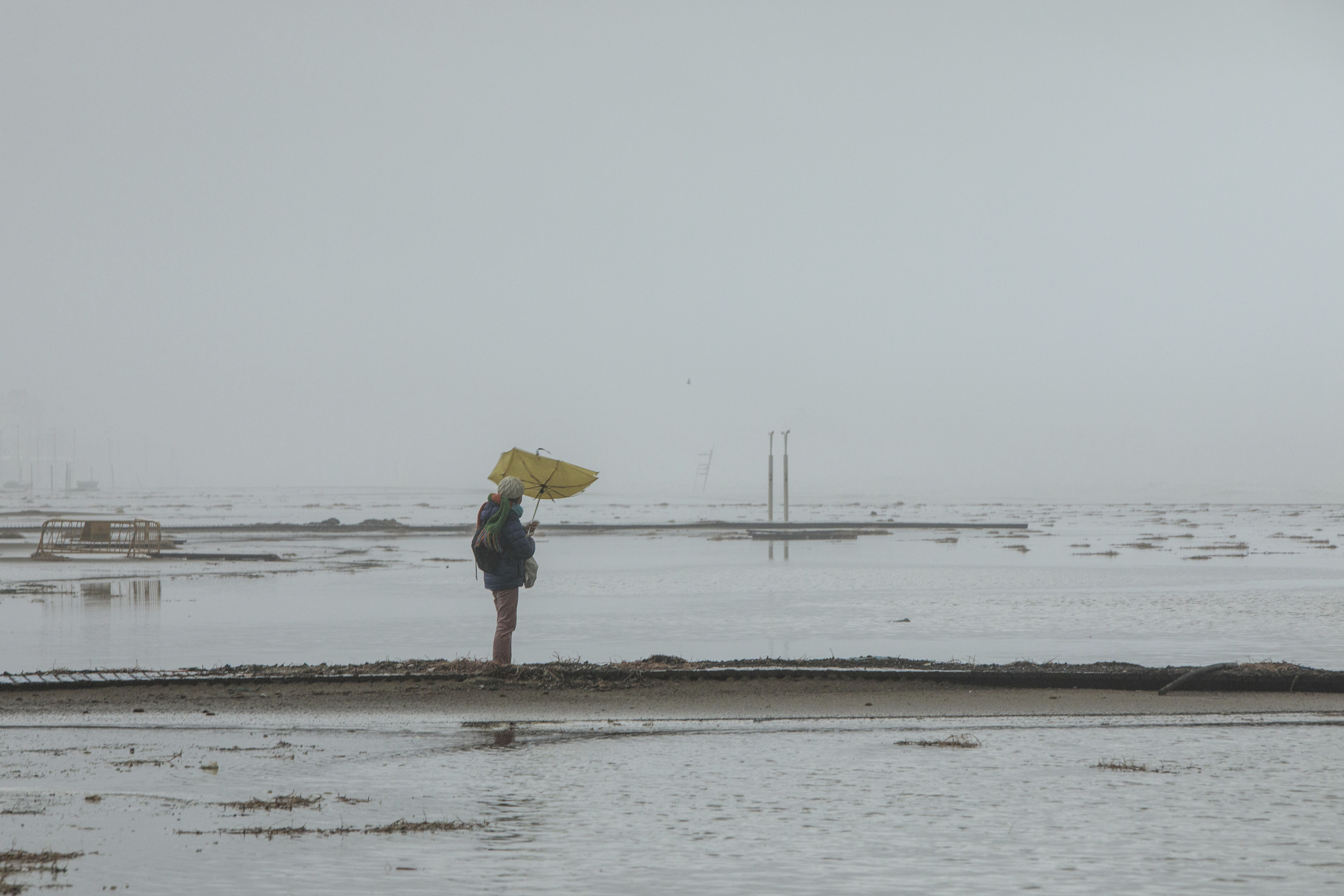 Una mujer con un paraguas en la playa de la malvarrosa.