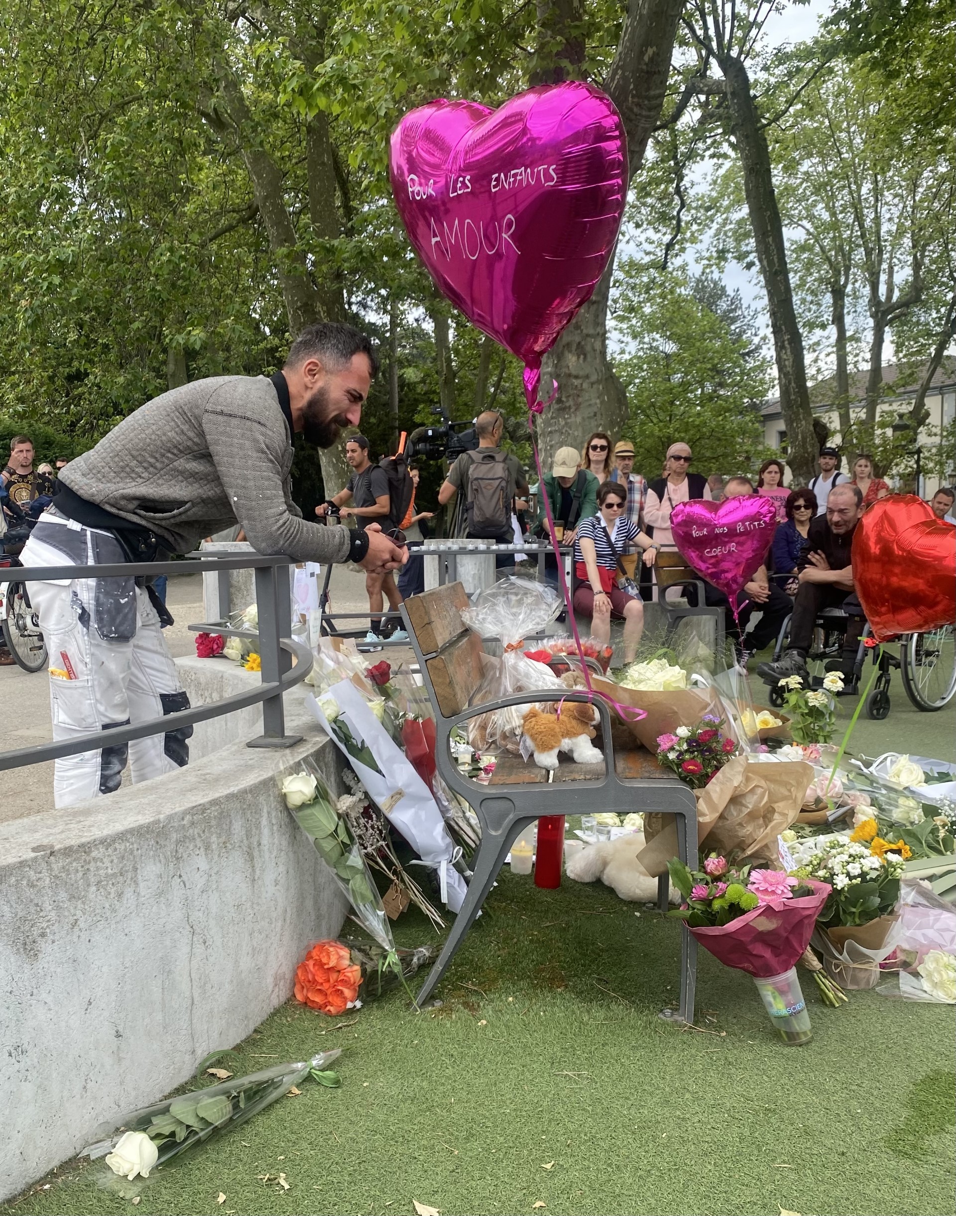 Un hombre llora frente a la ofrenda floral en Annecy