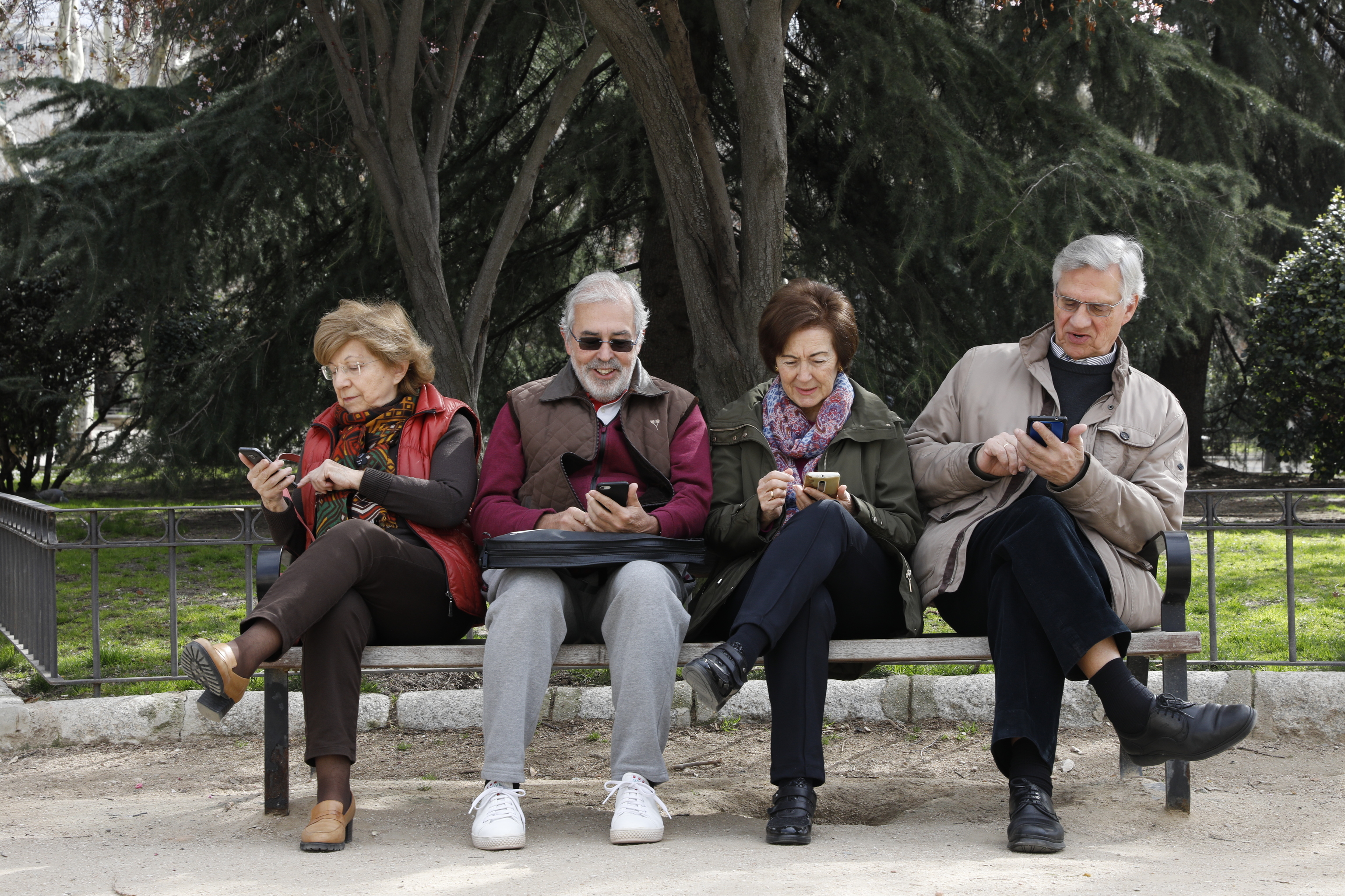 Varias personas mayores mirando su telfono mvil