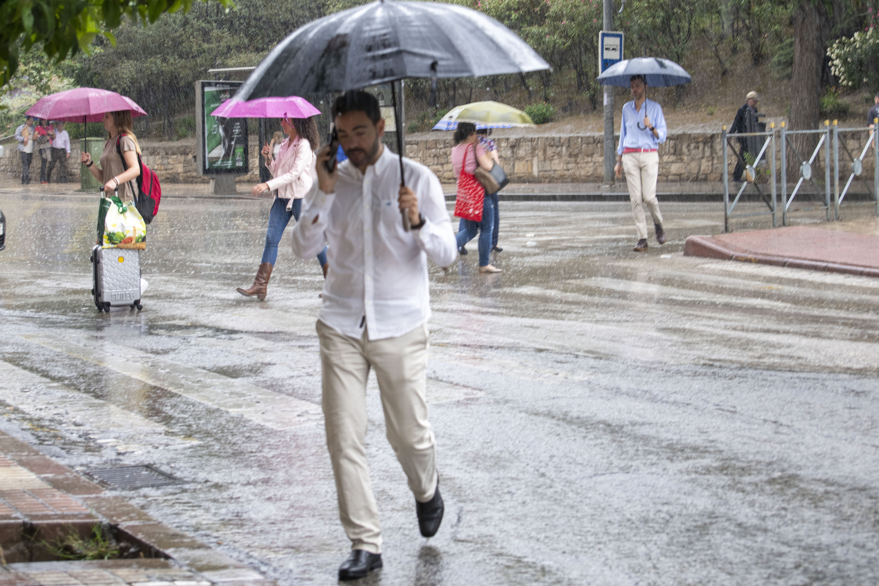 Varias personas con paraguas se refugian de las intensas lluvias que han caído esta semana en casi toda España.