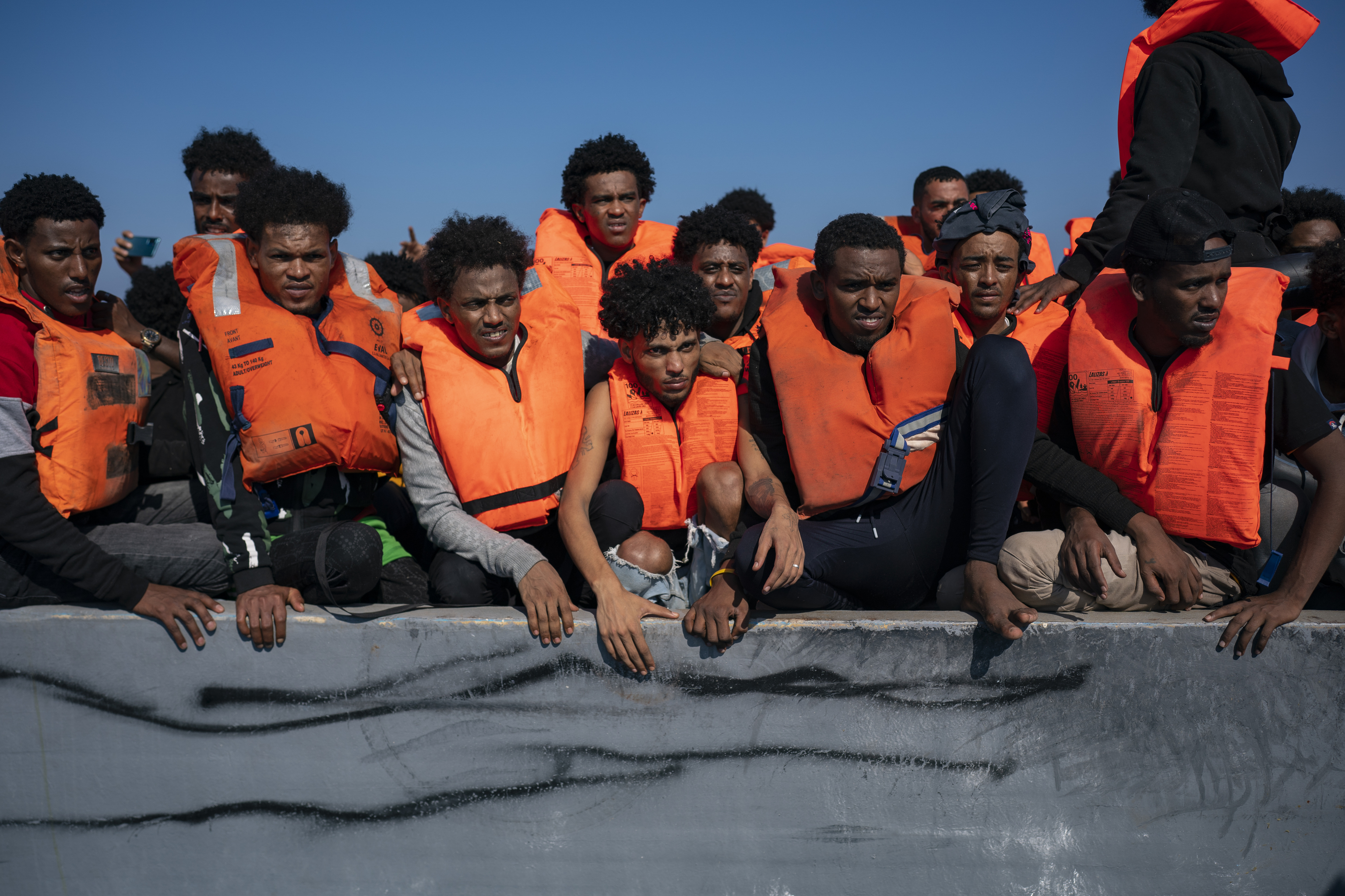 Migrantes procedentes de África se agolpan en un barco de madera, en el Mediterráneo.