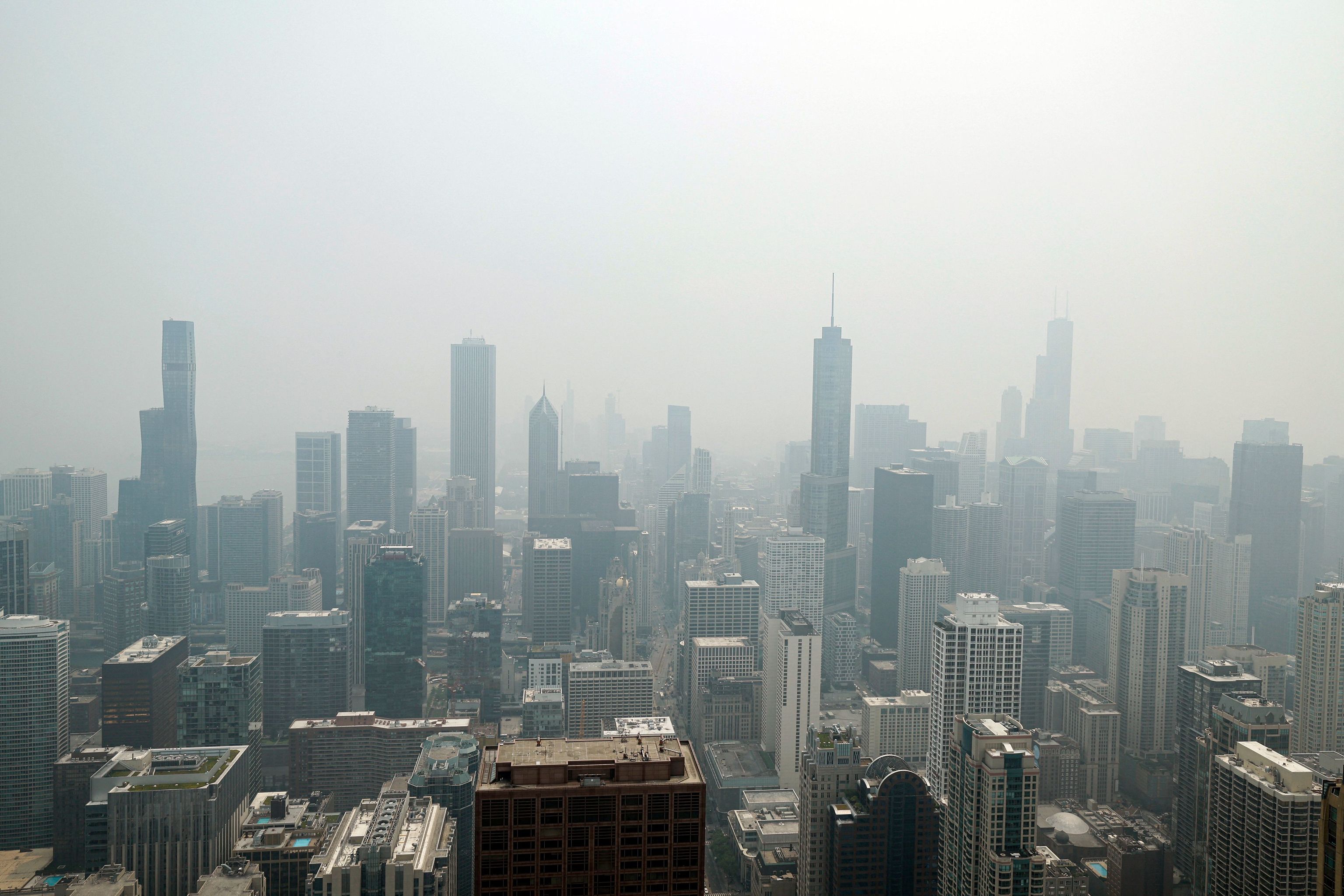 El horizonte de Chicago se ve desde la cubierta de observación 360 Chicago del edificio John Hancock con el humo pesado de los incendios forestales canadienses que cubren la ciudad, el 27 de junio de 2023, en Chicago, Illinois. El alcalde de Chicago, Brandon Johnson, dijo en un comunicado: "La ciudad de Chicago está vigilando cuidadosamente y tomando precauciones, ya que la Agencia de Protección Ambiental de EE.UU. (EPA) ha clasificado nuestro Índice de Calidad del Aire como "insalubre" debido al humo de los incendios forestales canadienses presentes en la región de Chicago. Recomendamos a los niños, adolescentes, ancianos, personas con enfermedades cardíacas o pulmonares y embarazadas que eviten actividades extenuantes y limiten su tiempo al aire libre."