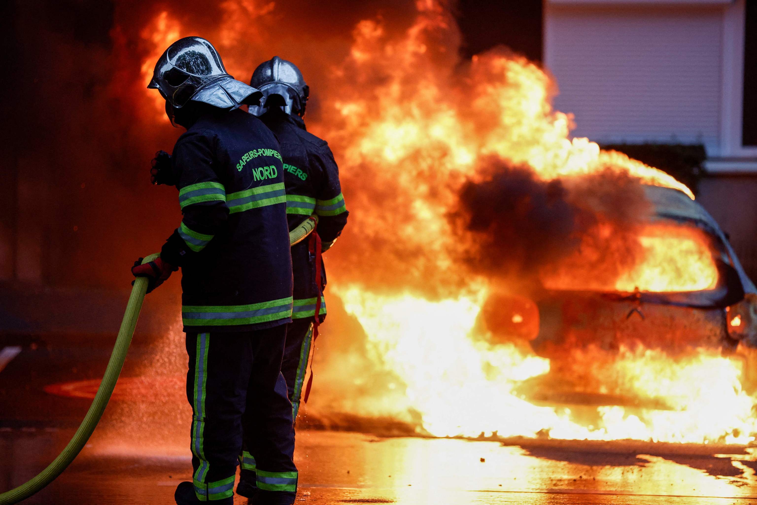 Los bomberos apagan un coche en llamas Durante las protestas en Lille, norte de Francia el 29 de junio de 2023, dos d