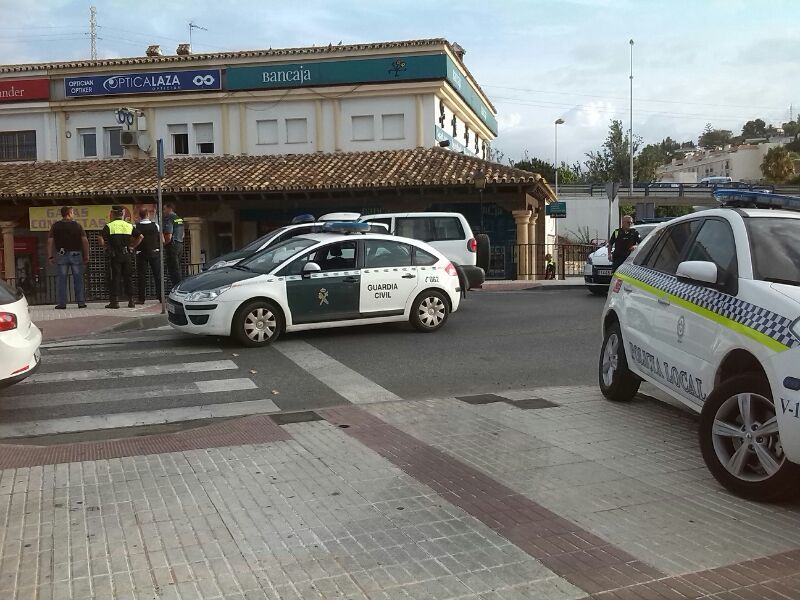 Miembros de la Guardia Civil frente a un banco de la Cala de Mijas, tras activarse el dispositivo de emergencia por atraco, aunque en realidad fue un desmayo lo que provoc