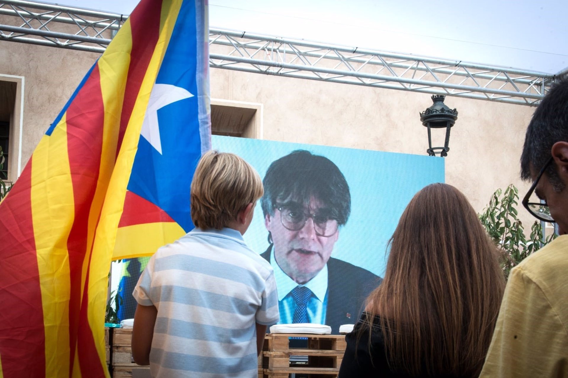 Carles Puigdemont, en pantalla, durante el acto de campaa de Junts en Amer (Girona).