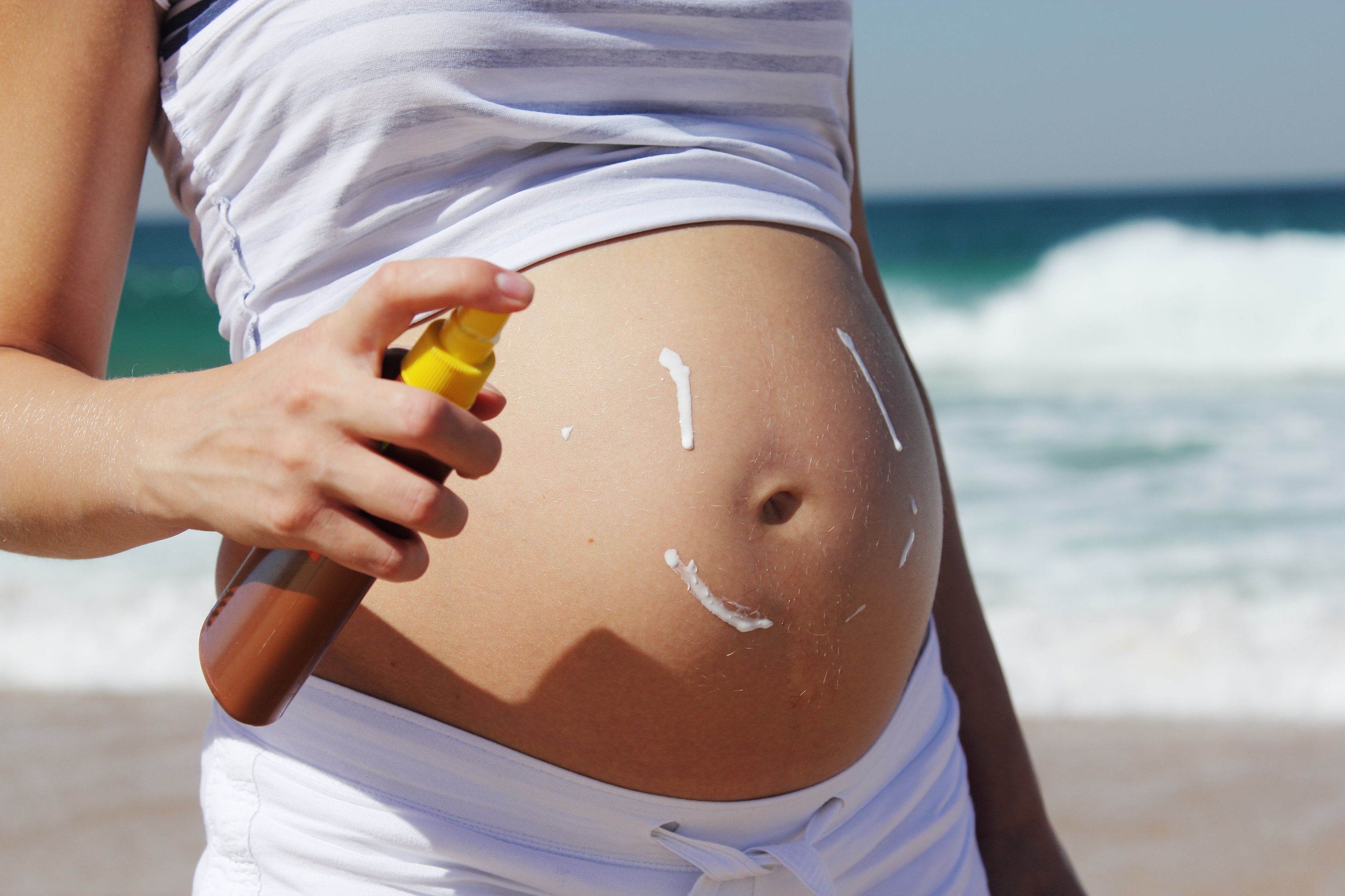 Embarazada echándose crema solar