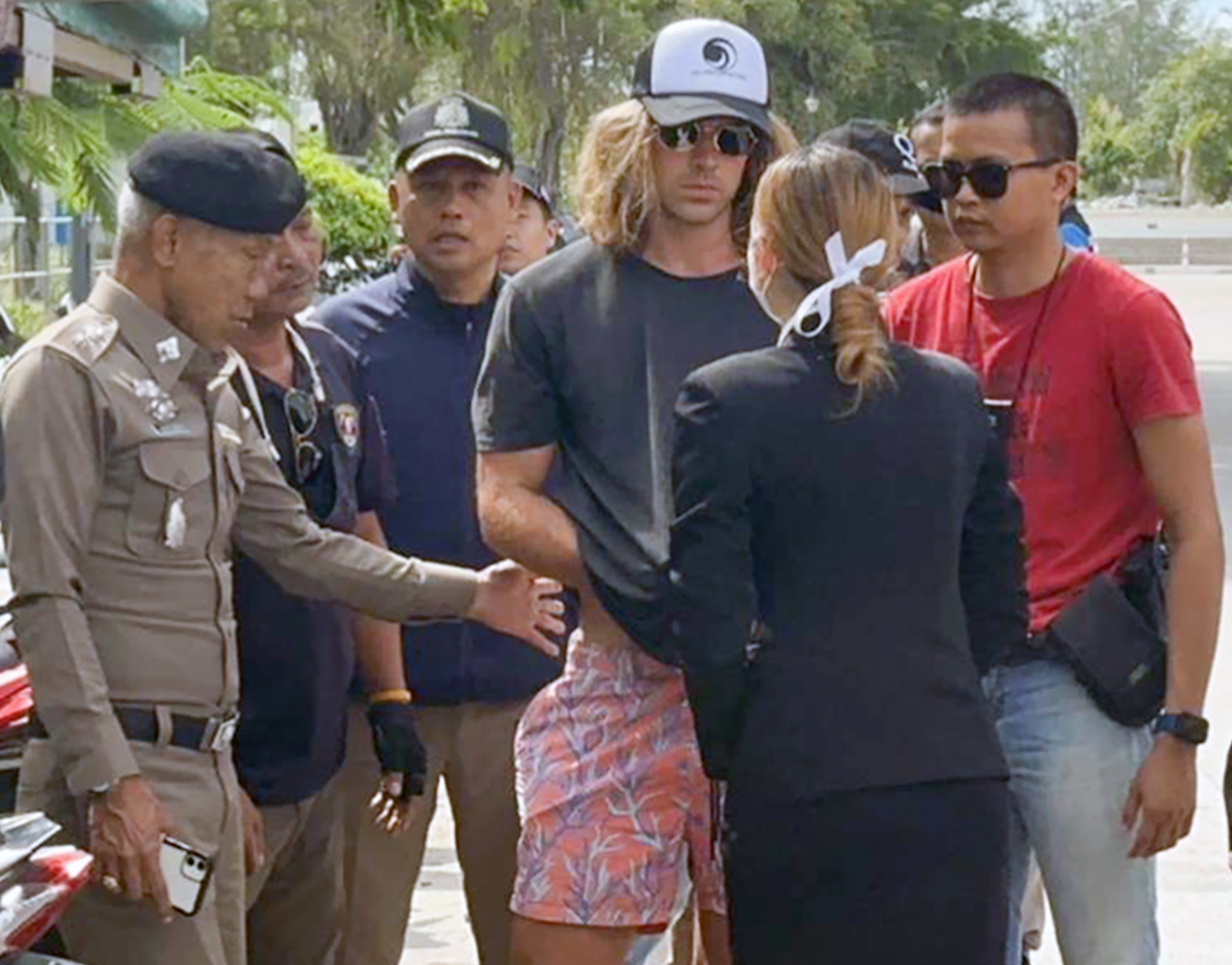 Daniel Sancho, con gorra, rodeado por agentes de policía tailandeses.