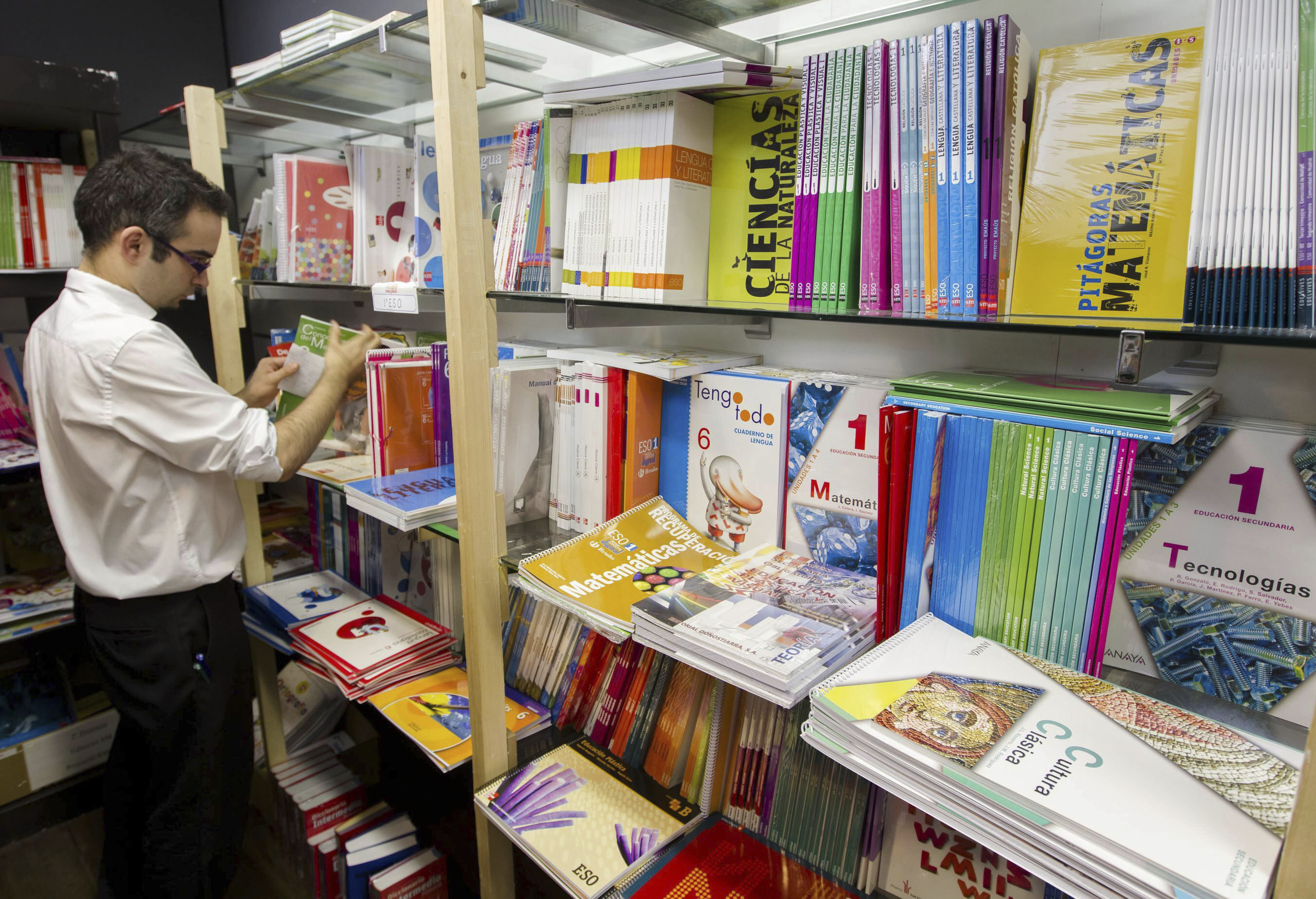 Dependiente de tienda organizando libros escolares.