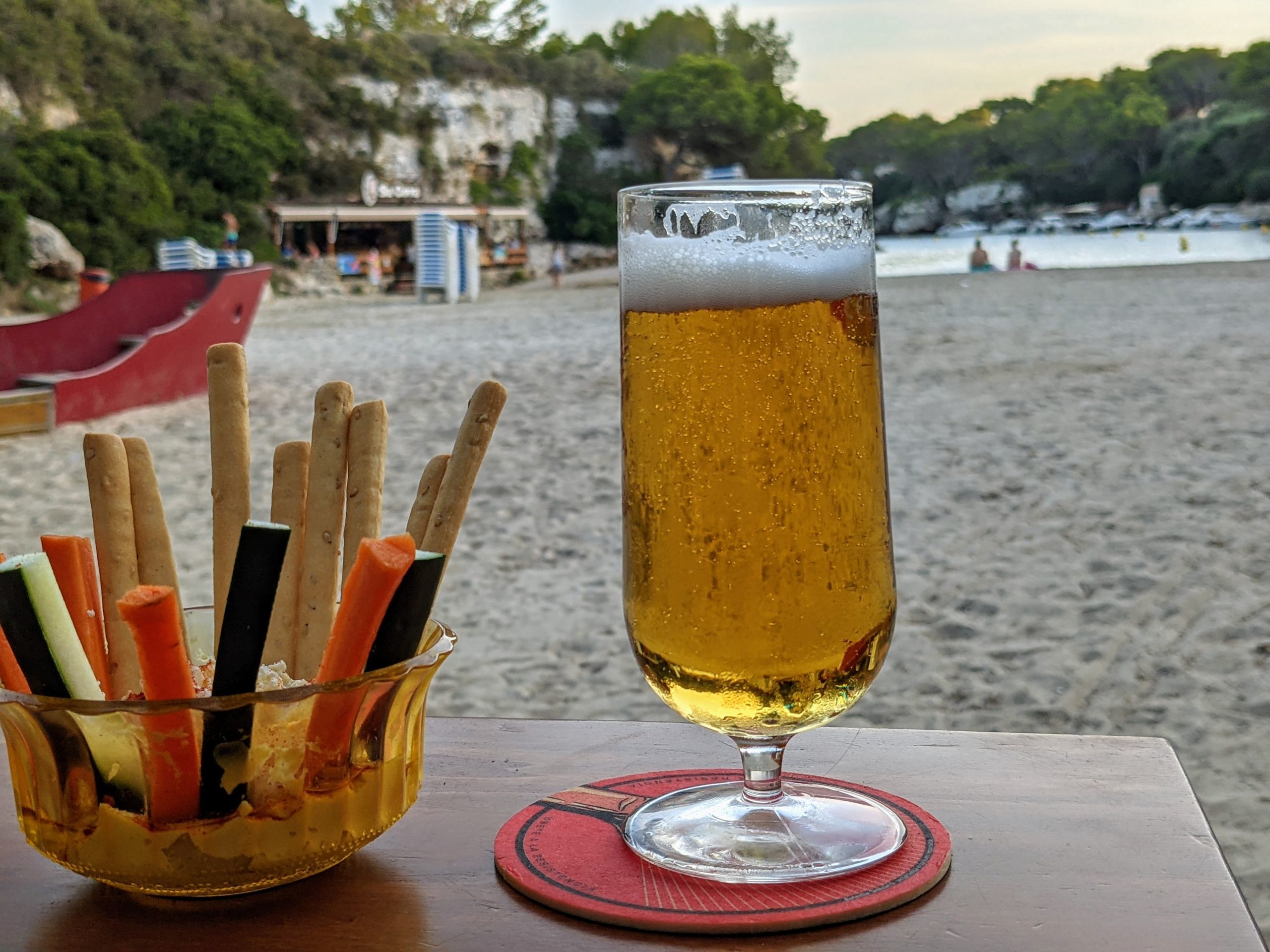Cerveza fría, crudités y hummus en Hopi Beach Bar, con vistas al mar.