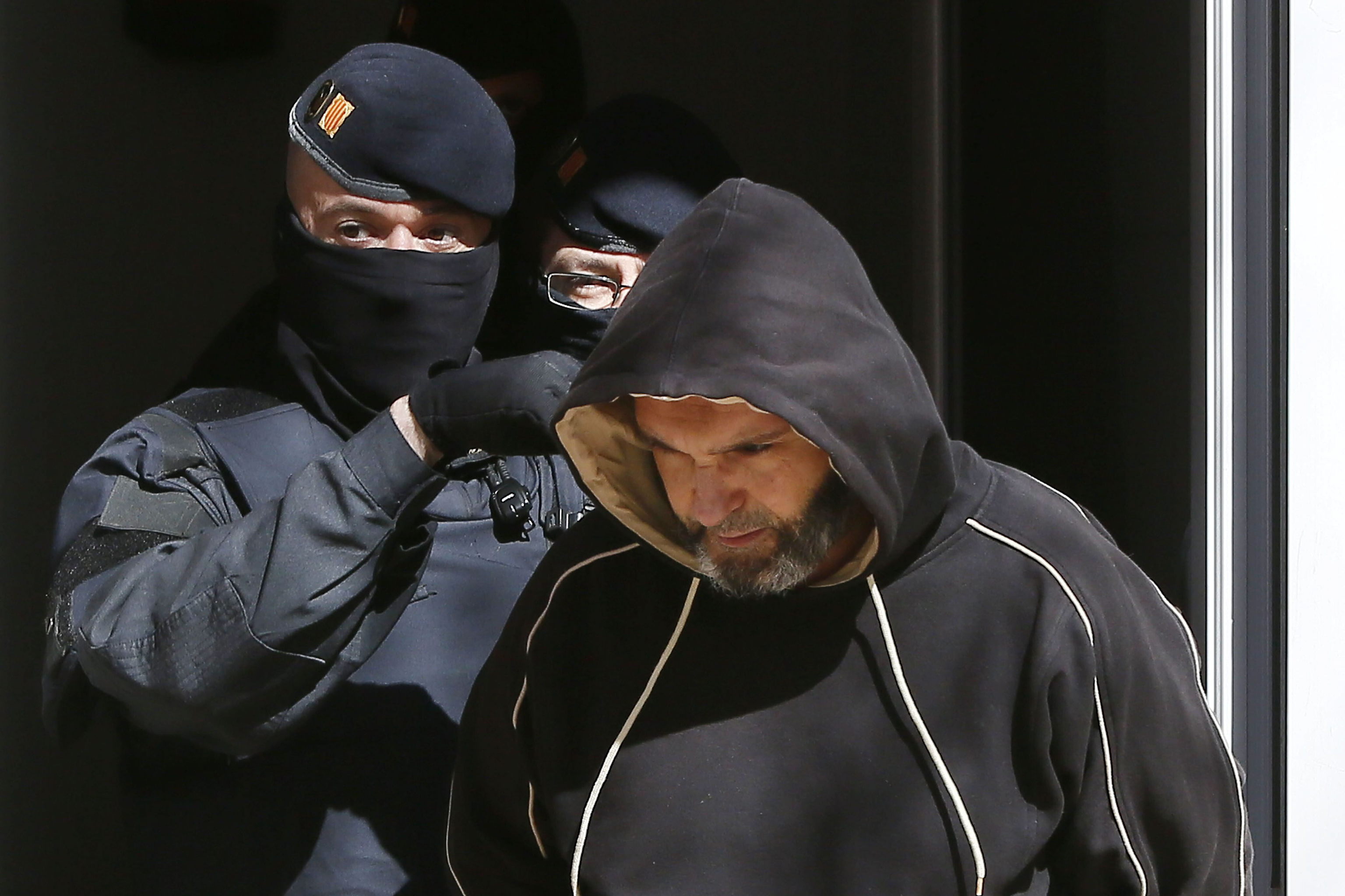 Un agente de los Mossos d'Esquadra custodia a un detenido por yihadismo