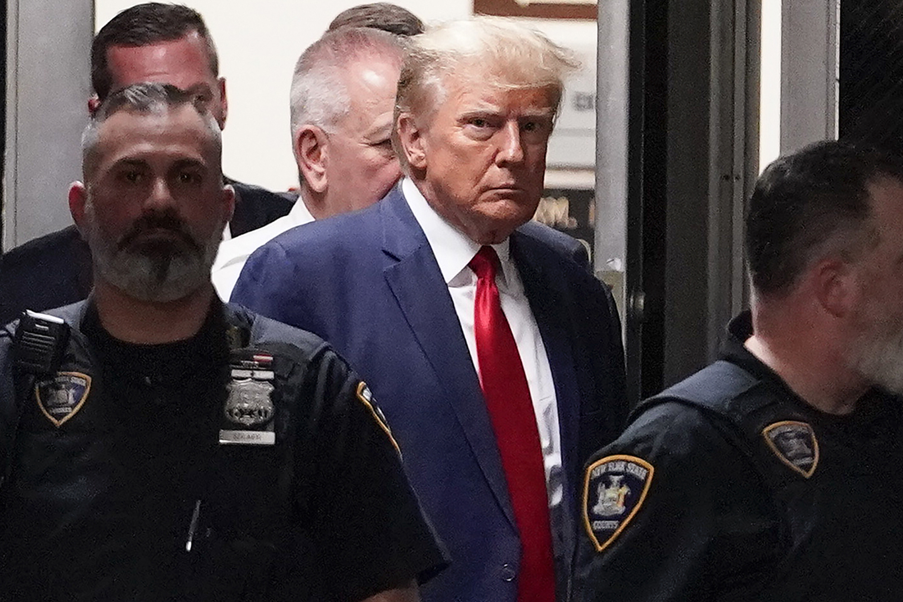 Donald Trump es acompaado hacia la sala de un tribunal en Nueva York en el mes de abril.