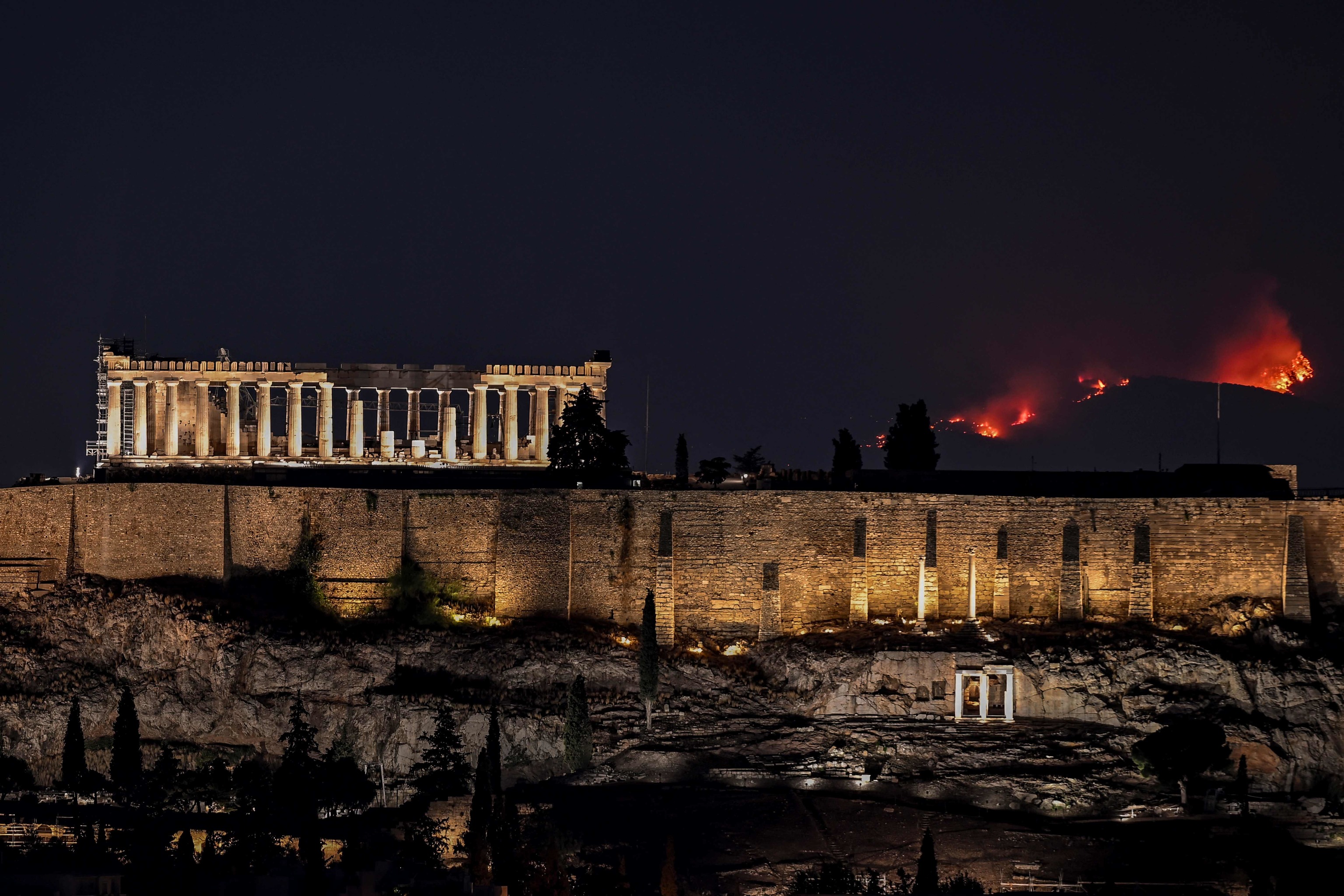 Un bosque arde detrs del antiguo templo del Partenn, en lo alto de la colina de la Acrpolis, mientras un incendio forestal arrasa las afueras de Atenas el 22 de agosto de 2023.