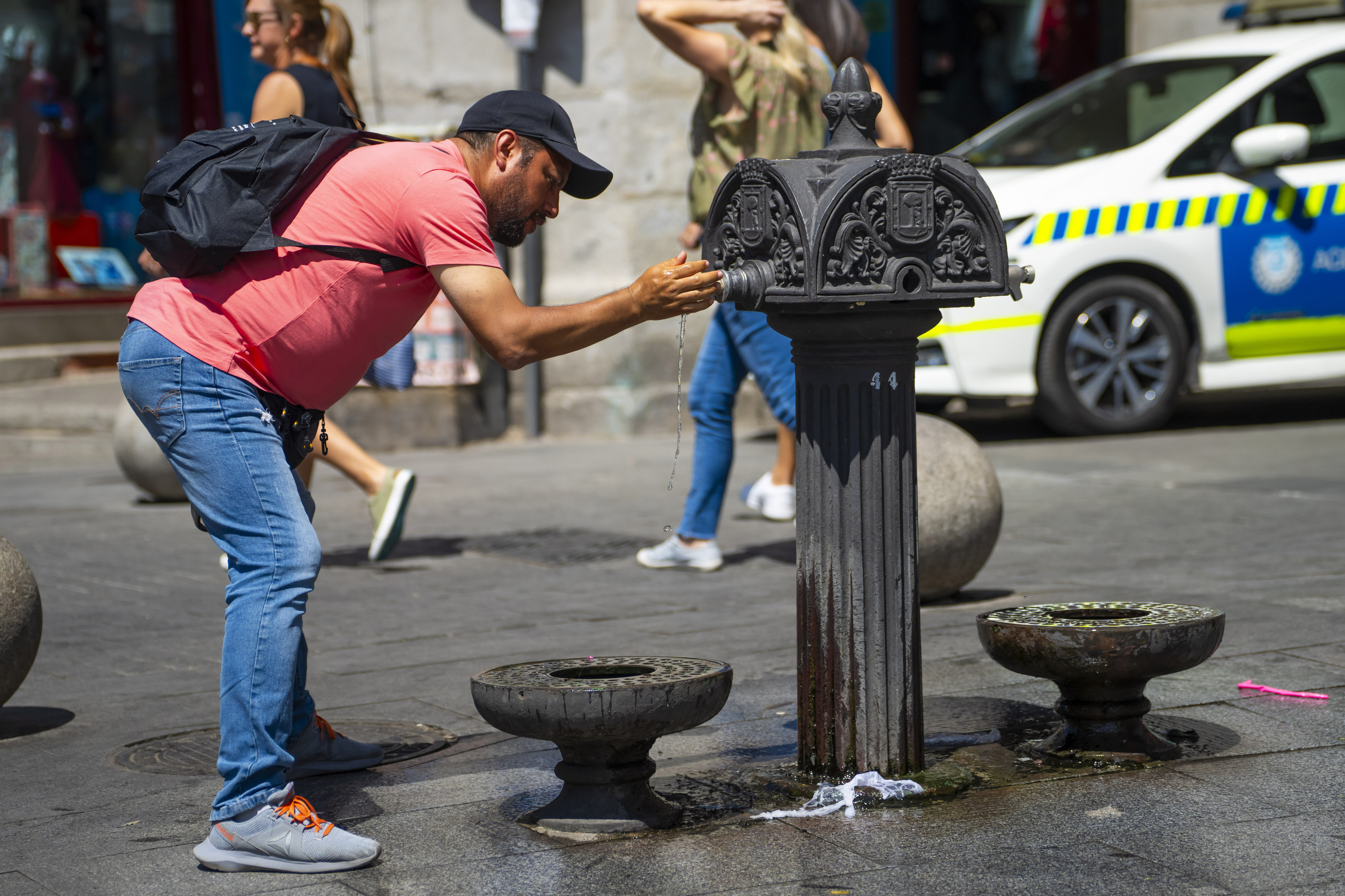 Un hombre bebe agua en una fuente del centro de Madrid.