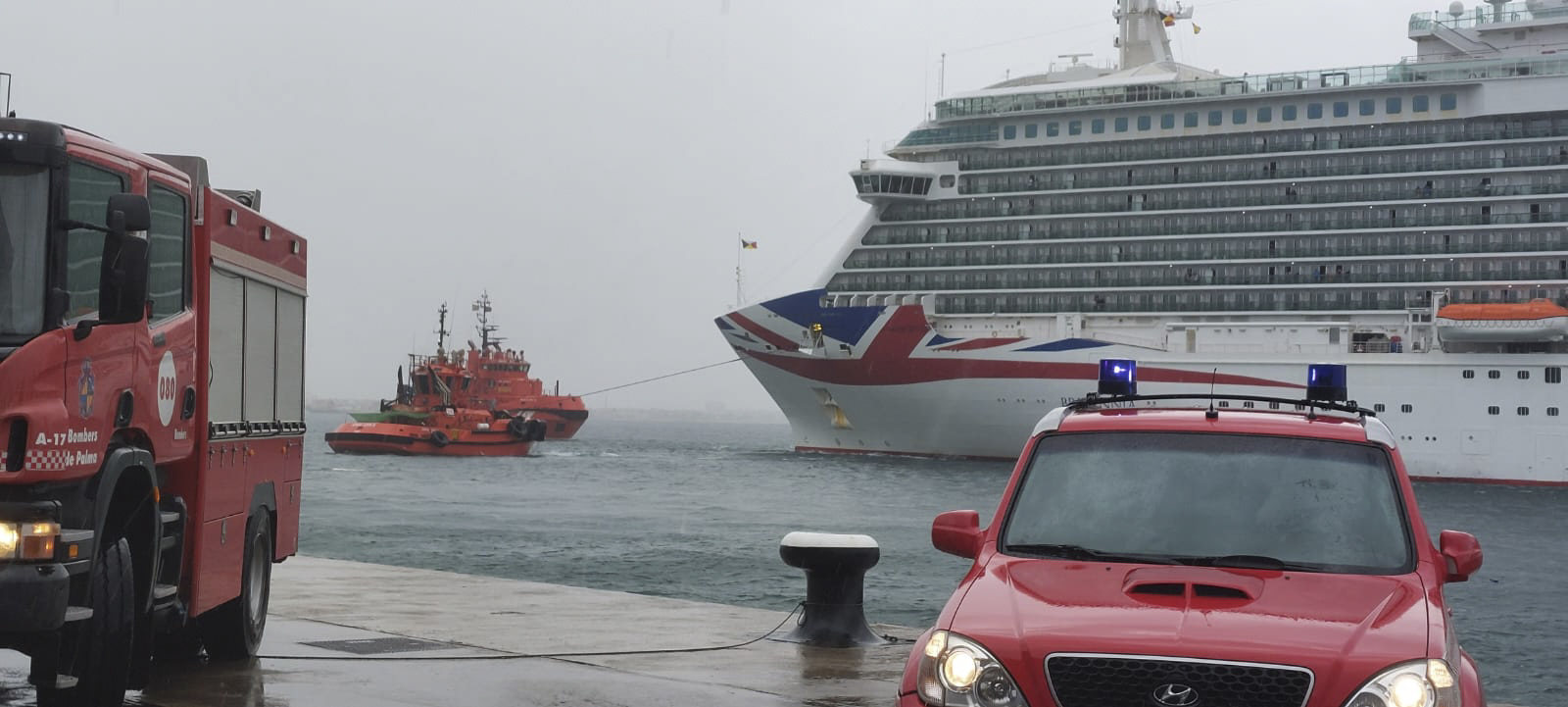 Un remolcador tira del Britannia , atracado en el puerto Palma, que choc este domingo contra un petrolero.