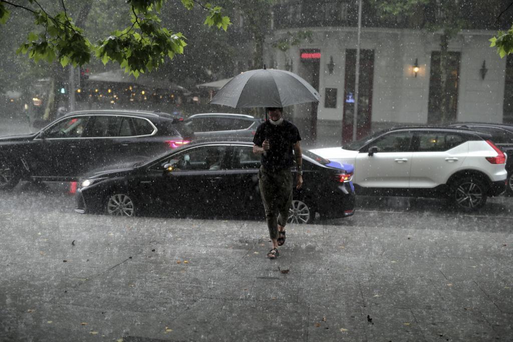 Un hombre bajo una intensa tormenta en Madrid.