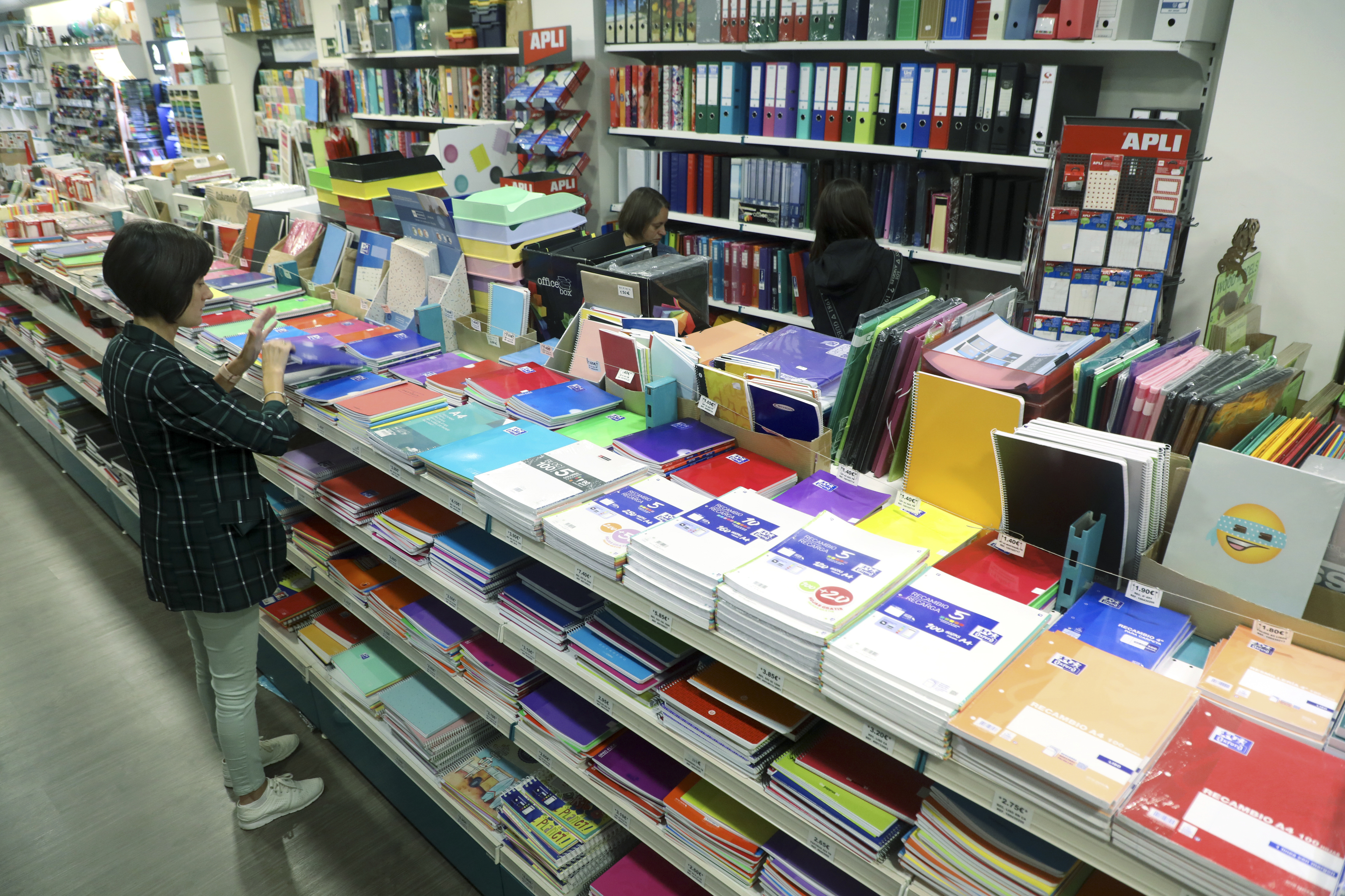 Una mujer mira material escolar en una papeler