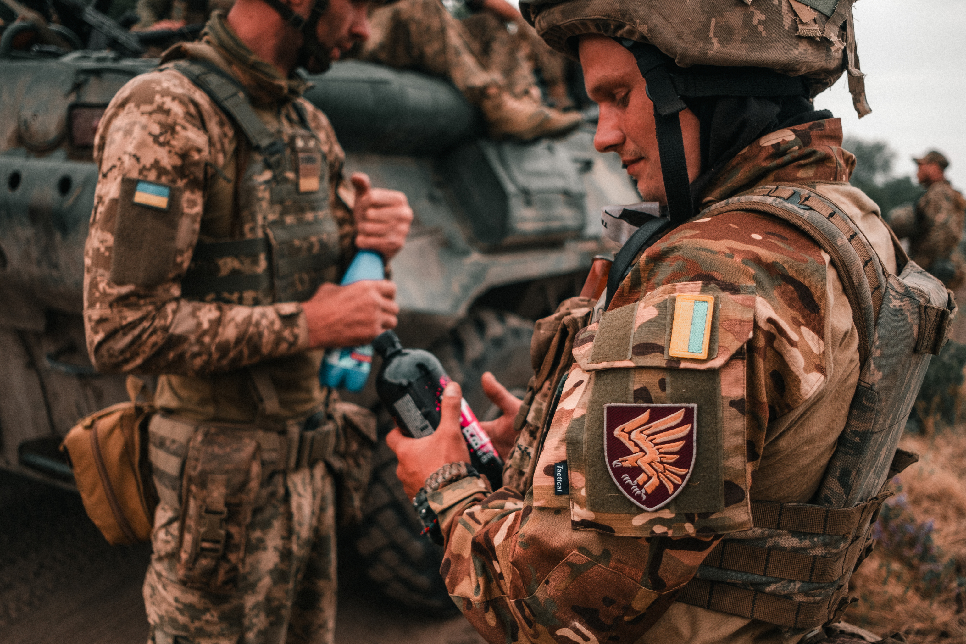 Soldado ucraniano con esquema multicam junto a otros compañeros con camuflaje pixelado.