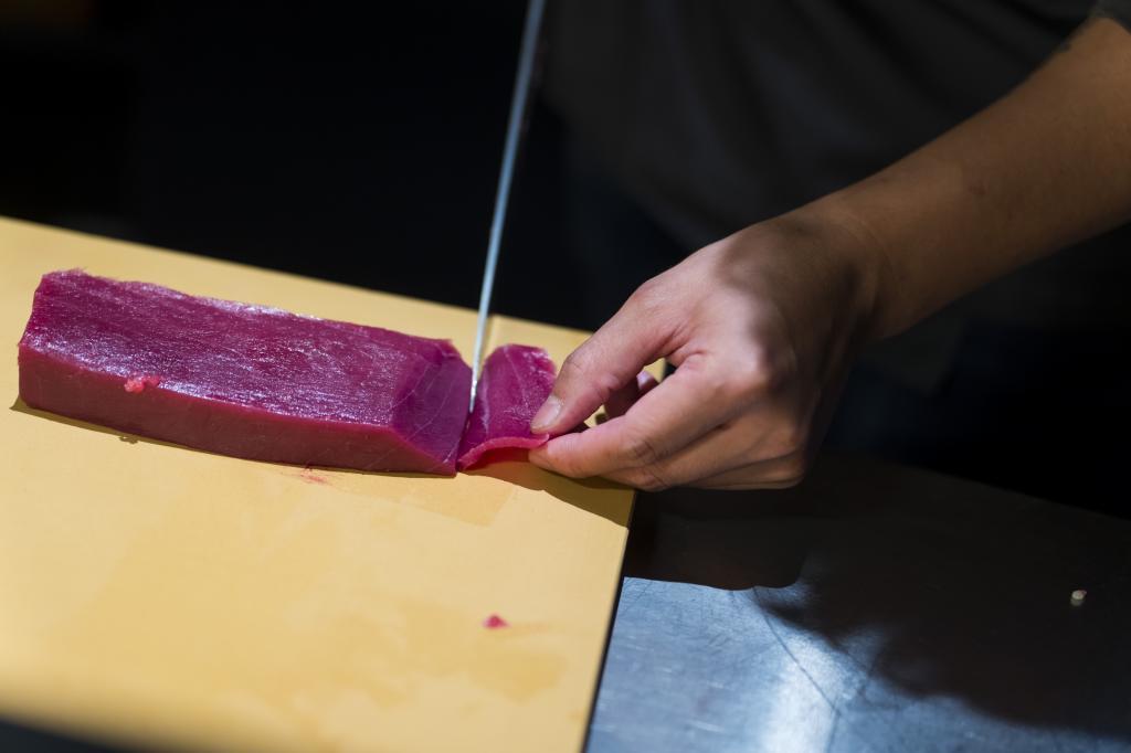 El chef cortando una pieza de atún.