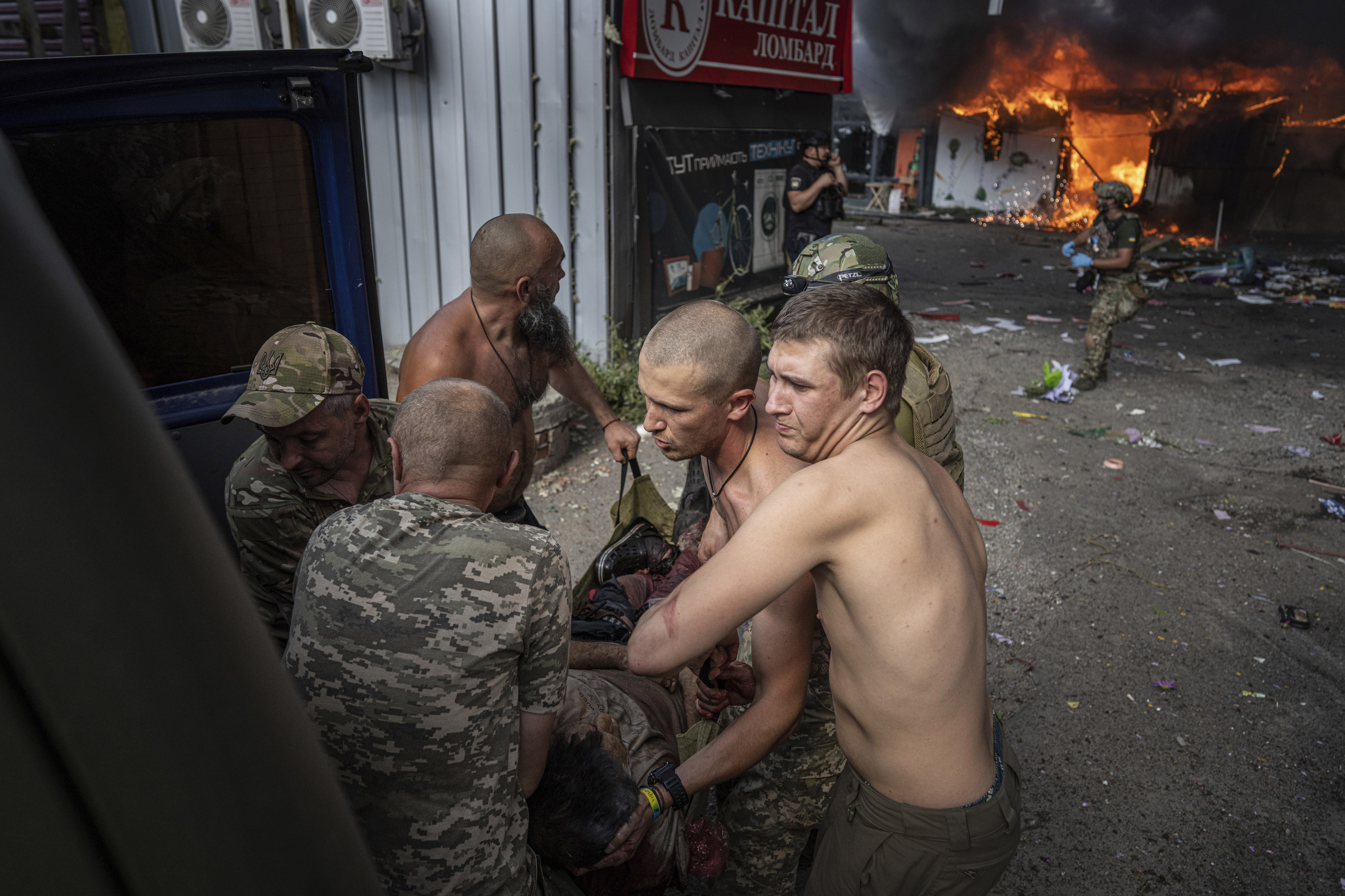 Soldados ucranianos trasladan a una mujer herida tras un ataque ruso a un mercado en Kostiantynivka.