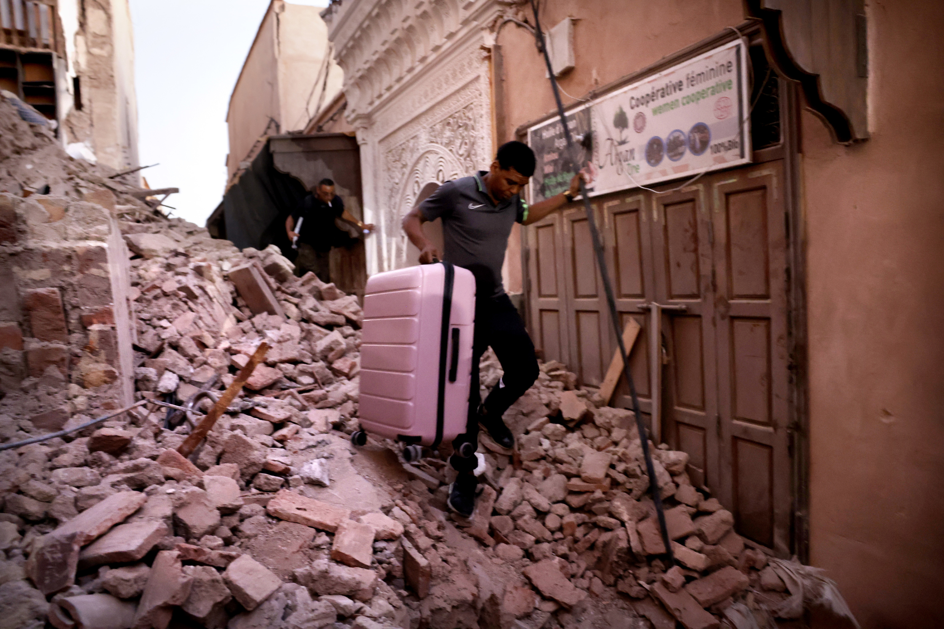 Un joven trata de salir entre escombros con su maleta de Marrakech.