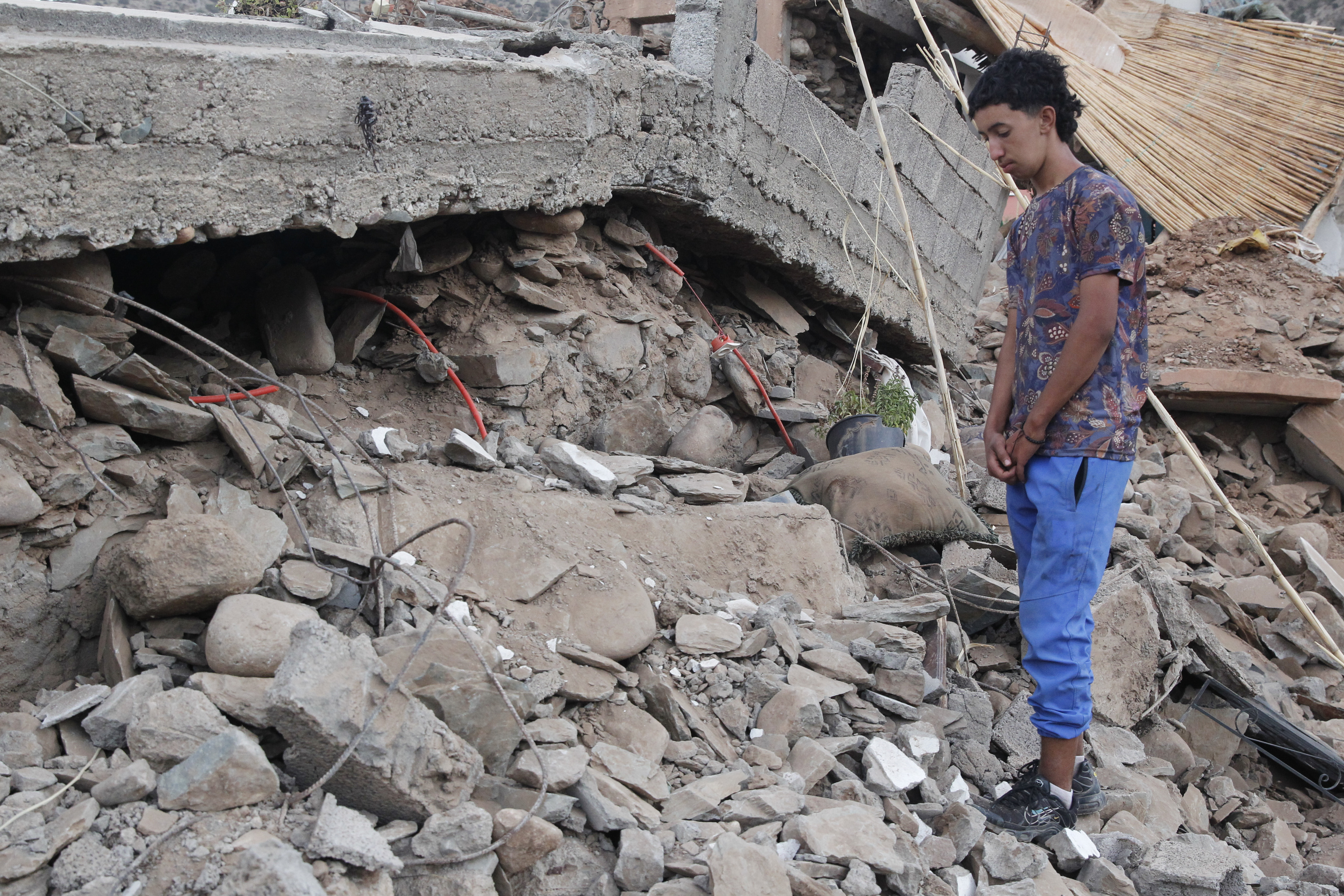 Un chico mira la casa derruida en la que murieron su padre y hermana por culpa del terremoto.