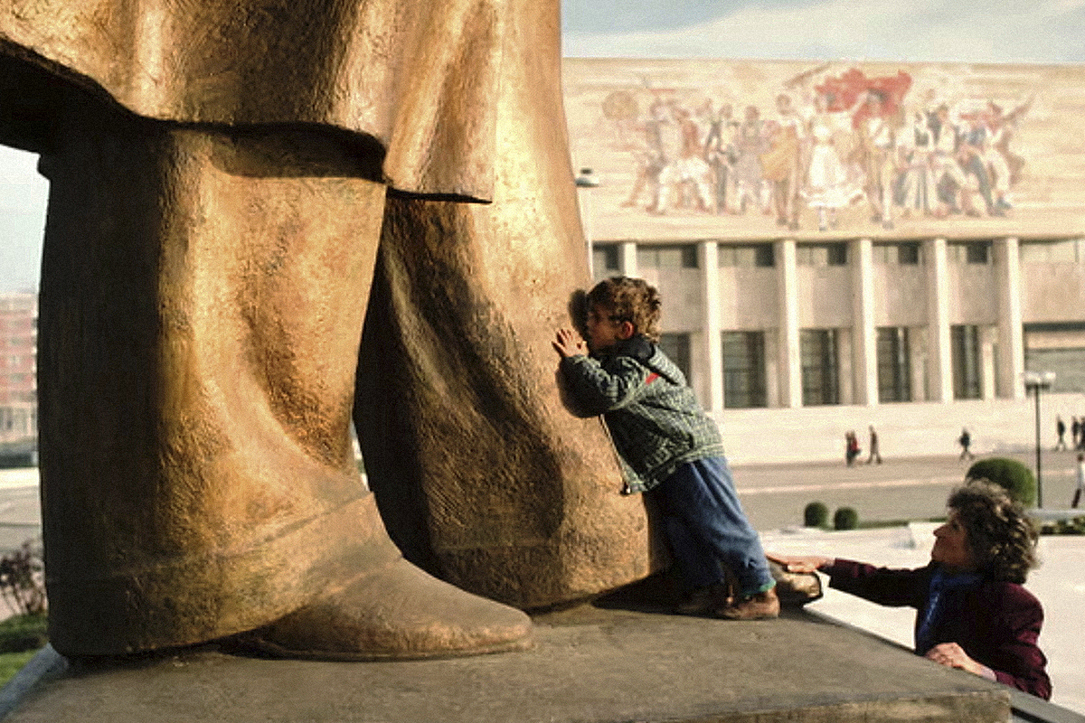 Un niño besando los pies de la estatua de Enver Hoxha en Tirana, 1990.