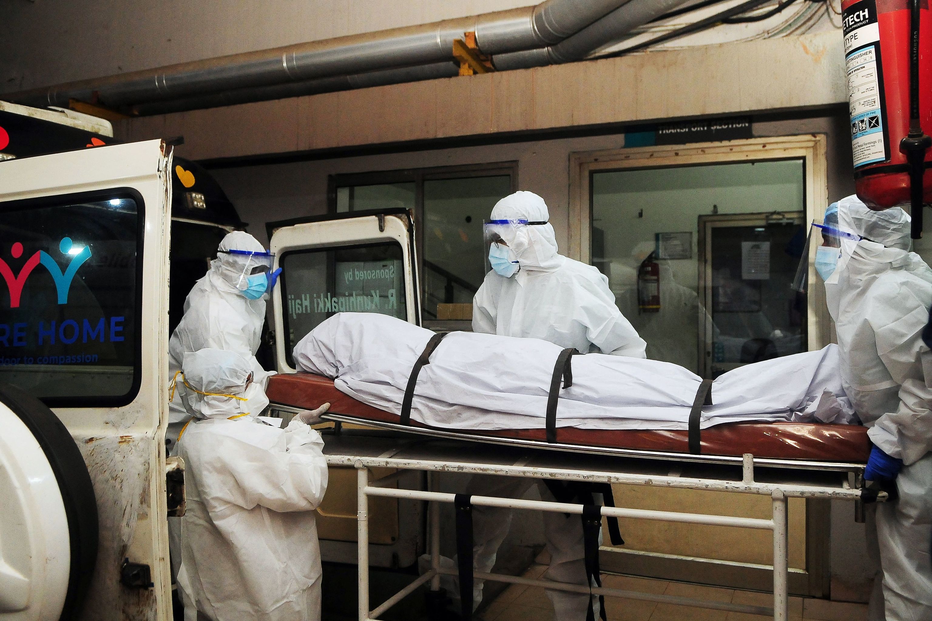 Trabajadores trasladan un cuerpo de una persona infectada de Nipah.