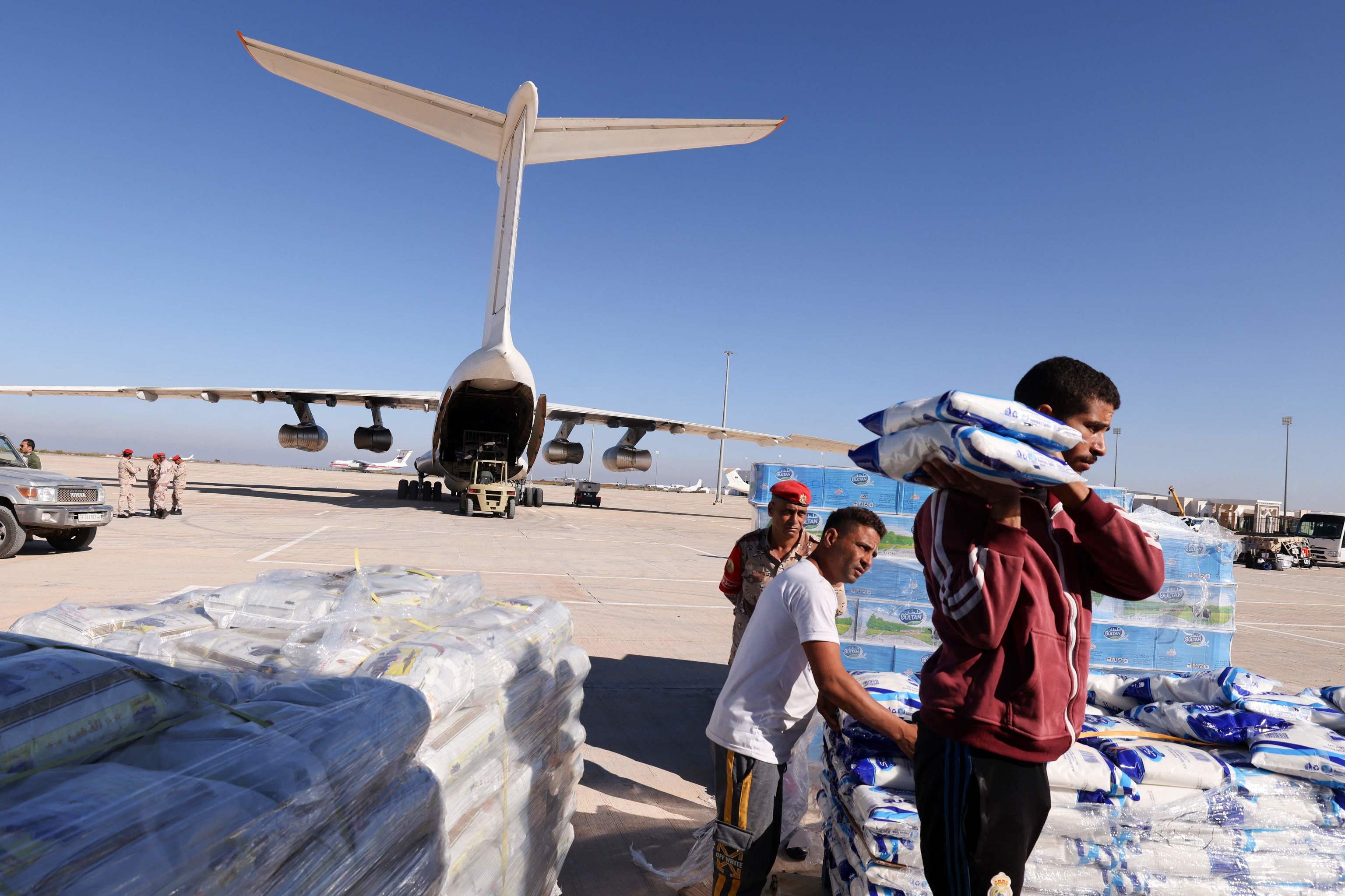 Un trabajador transporta ayuda suministrada por los EAU para los supervivientes de las inundaciones que sumergieron la ciudad oriental libia de Derna, llegan al aeropuerto de Bengasi el 16 de septiembre de 2023. Las inundaciones arrastraron al mar a miles de personas y viviendas despu
