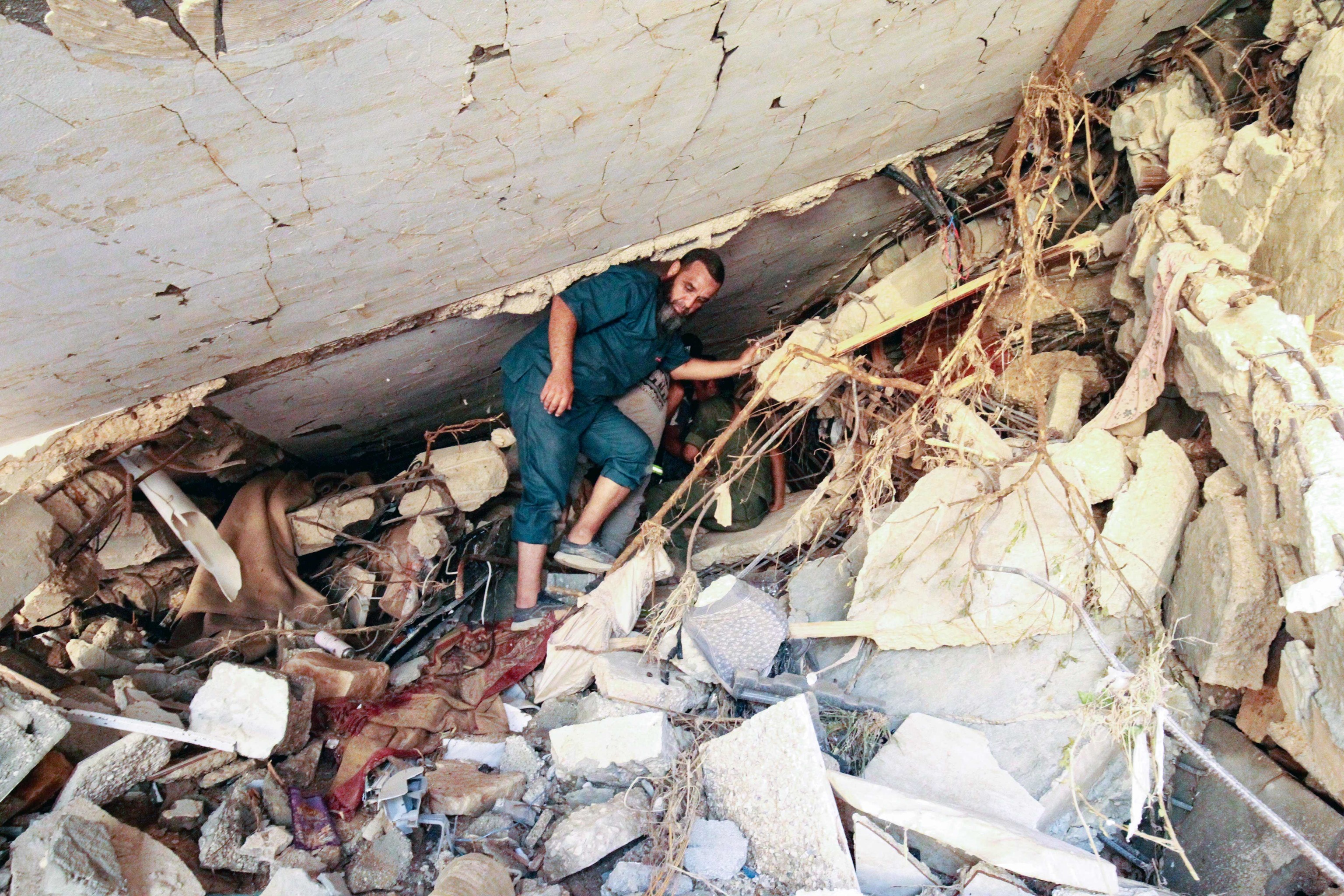 Varias personas buscan supervivientes entre los escombros de un edificio que se derrumb
