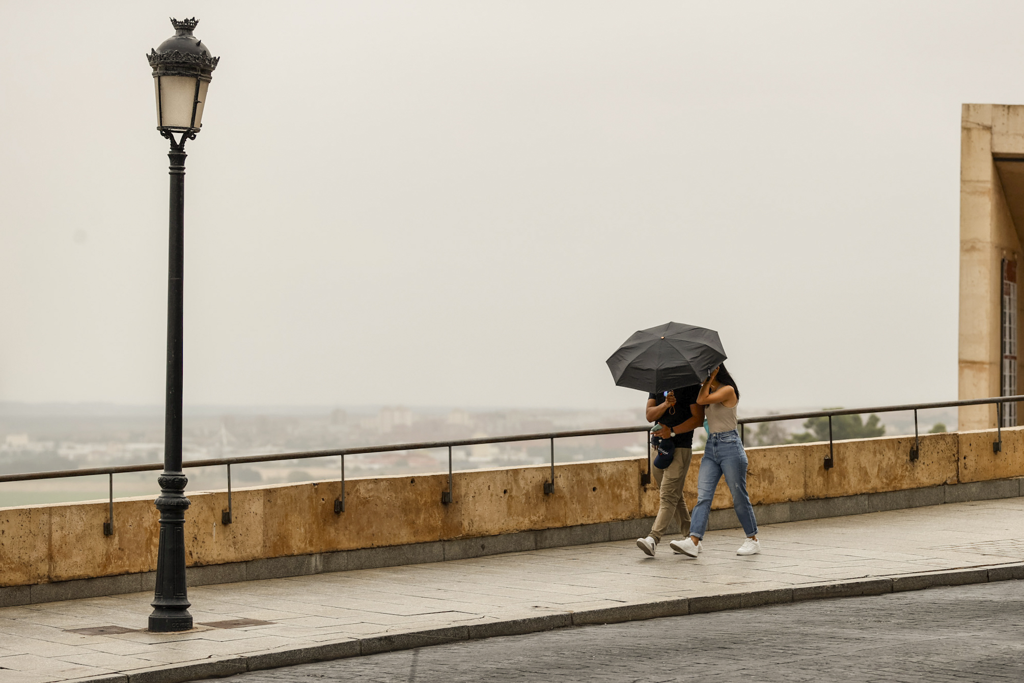 Una pareja se protege de la lluvia en Toledo.